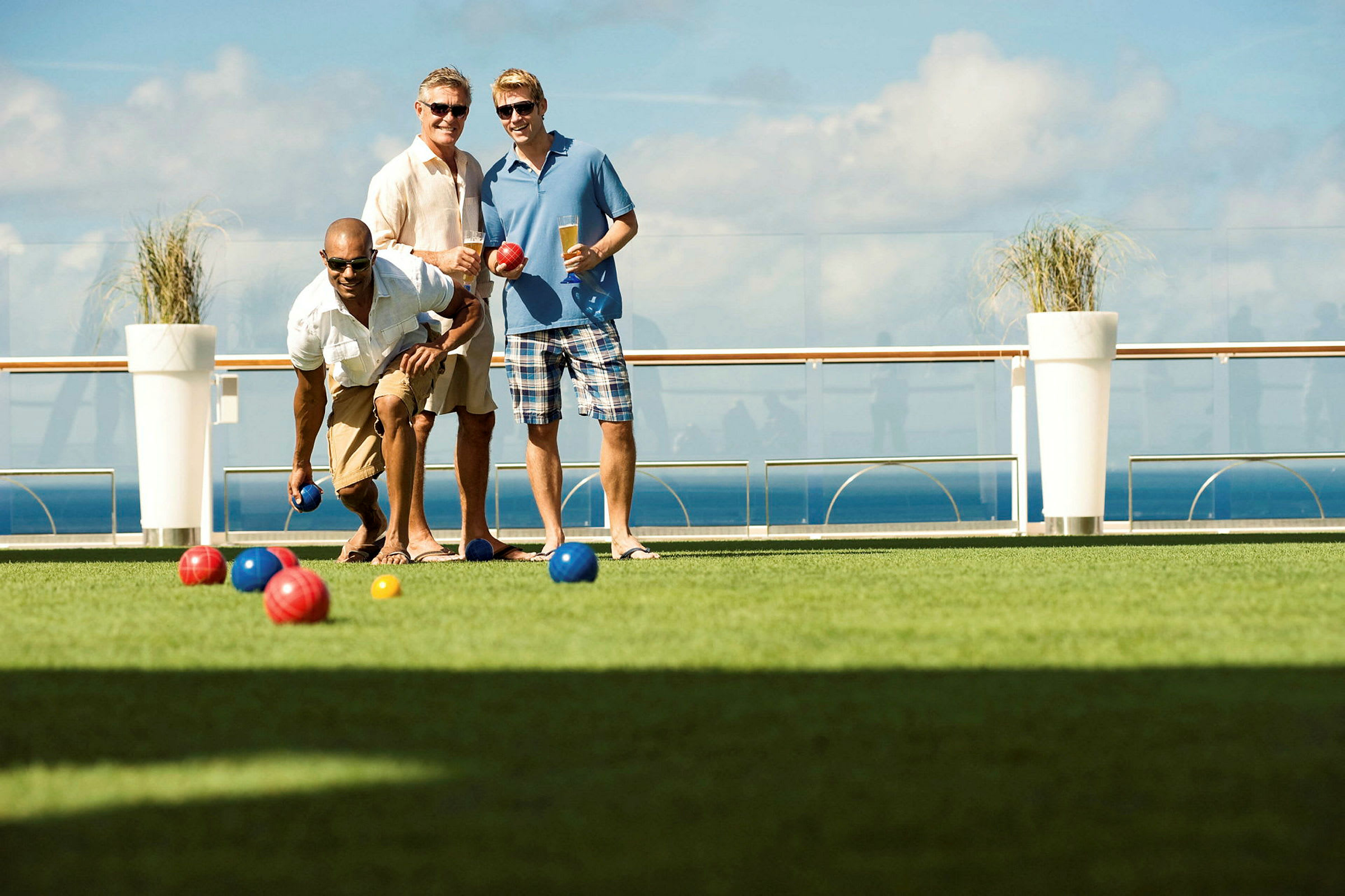 Personer spelar boule på en gräsmatta vid havet. (AI-genererad text)