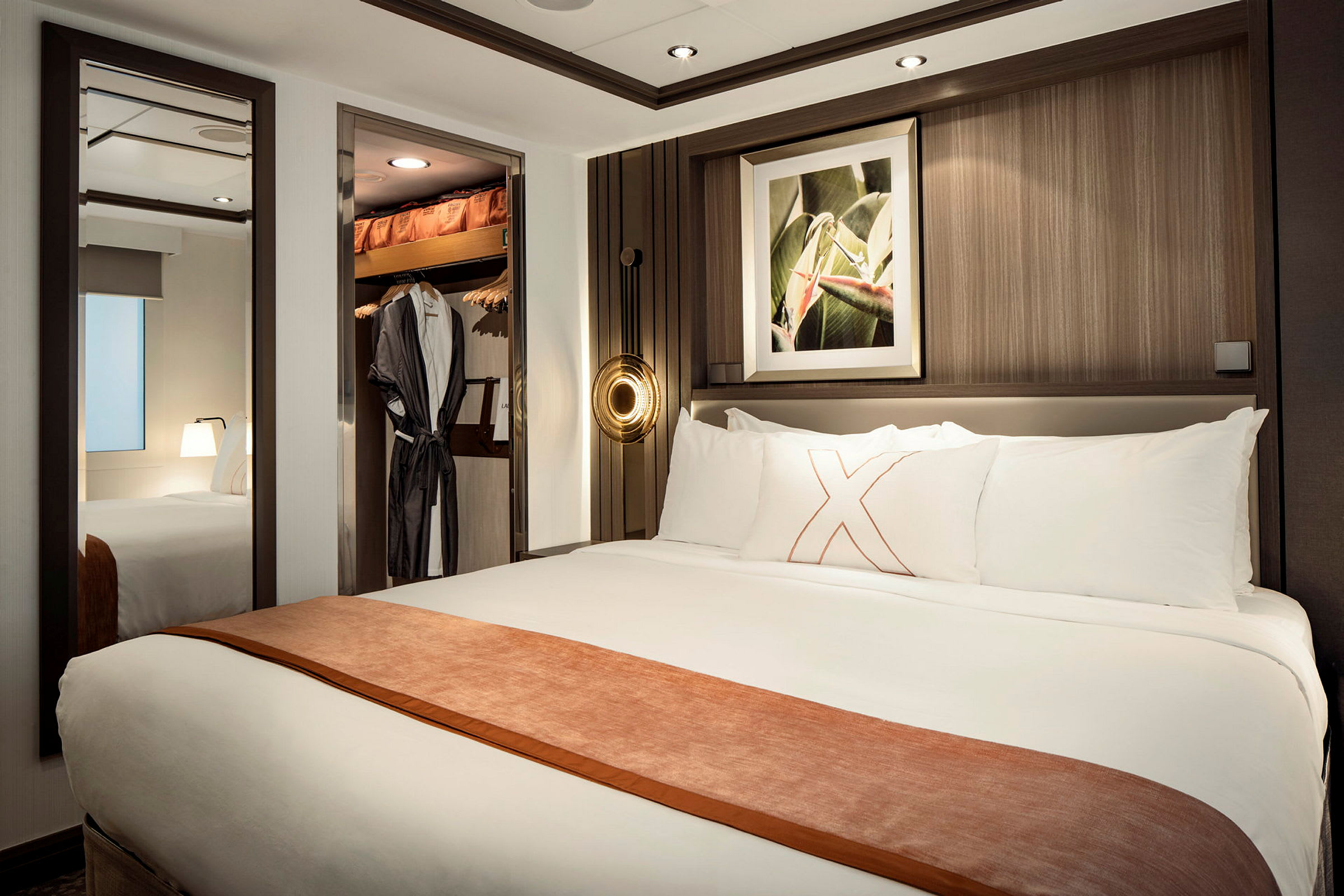 Ett hotellrum med en dubbelsäng, väggdekoration och öppet garderobsutrymme. (AI-genererad text)