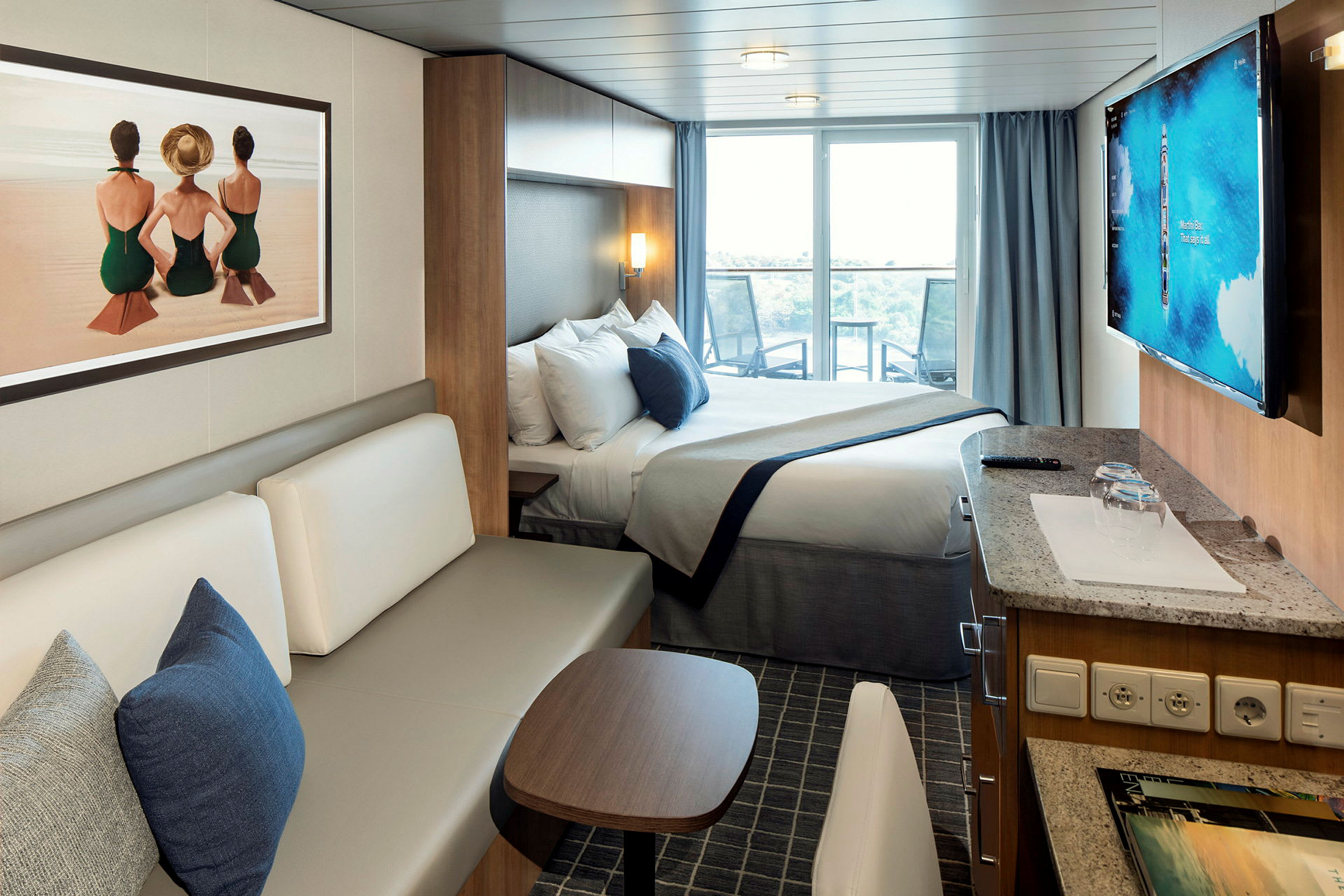 Ett modernt hotellrum med en säng, soffa, och balkong. Konstverk på väggen föreställer tre personer vid en strand. (AI-genererad text)