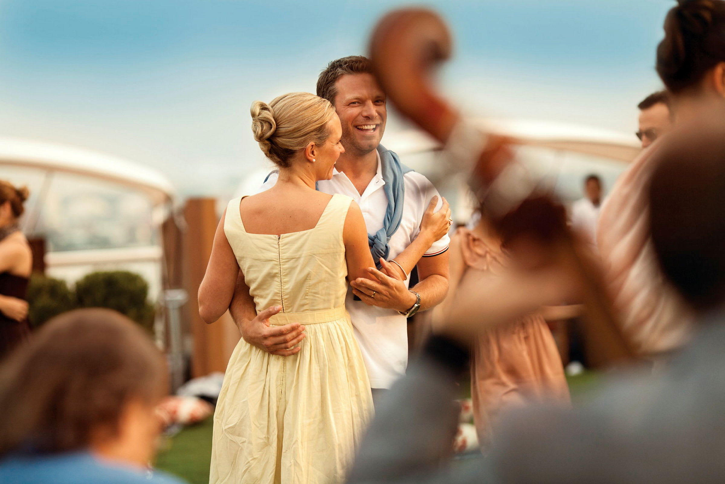 Två personer dansar vid en fest på gräsmattan med musiker i förgrunden. (AI-genererad text)