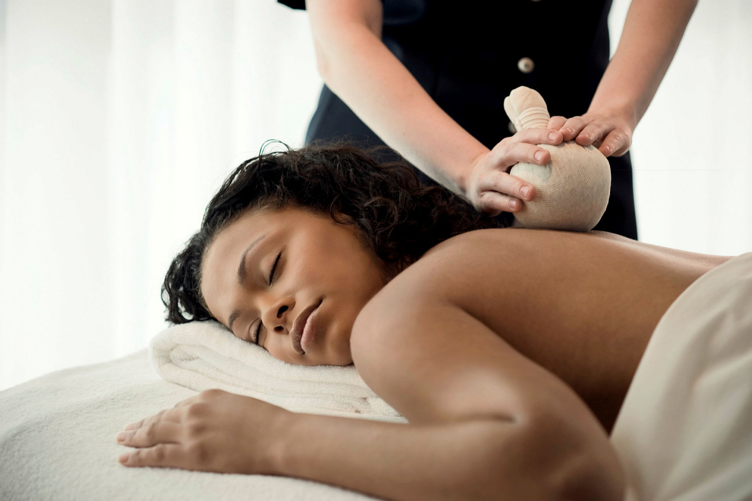 Person får massage med en örtpåse. (AI-genererad text)