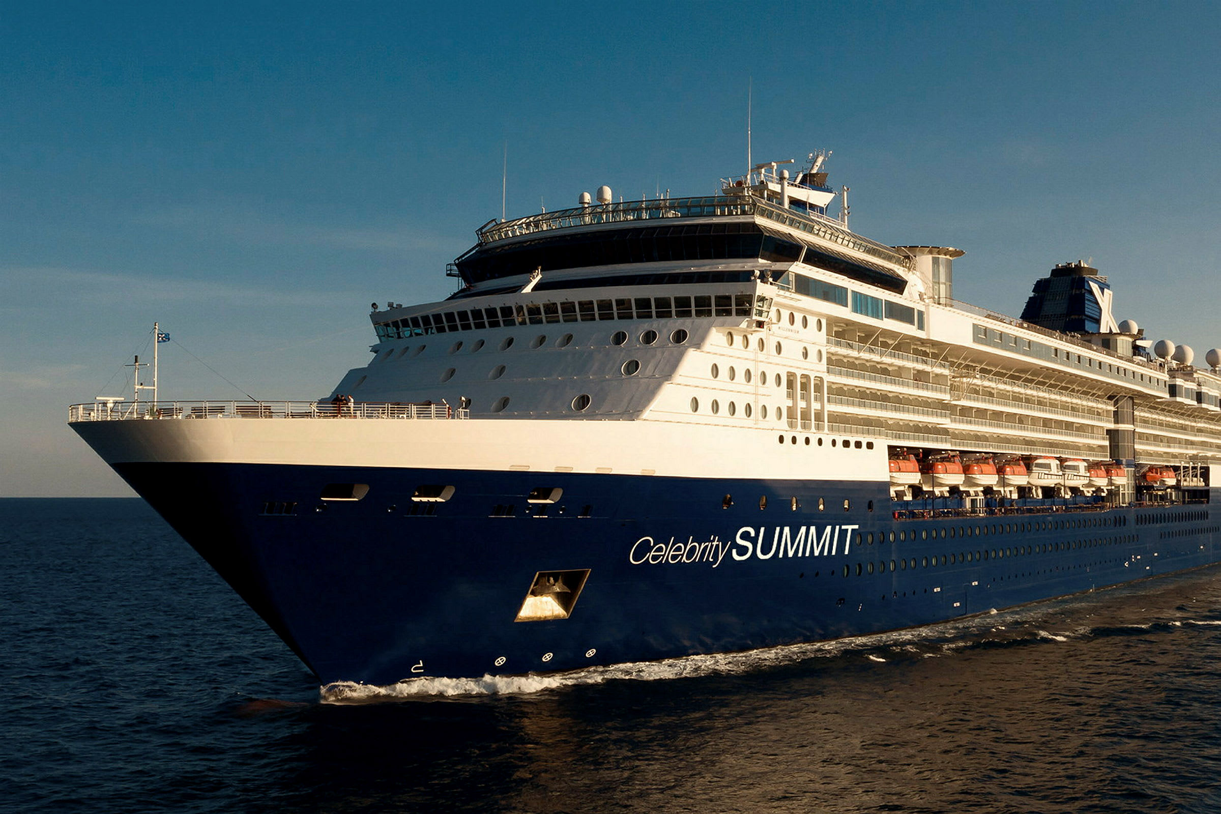 En blå och vit kryssningsfartyg med texten 'Celebrity SUMMIT' på sidan, som seglar på havet under en blå himmel. (AI-genererad text)