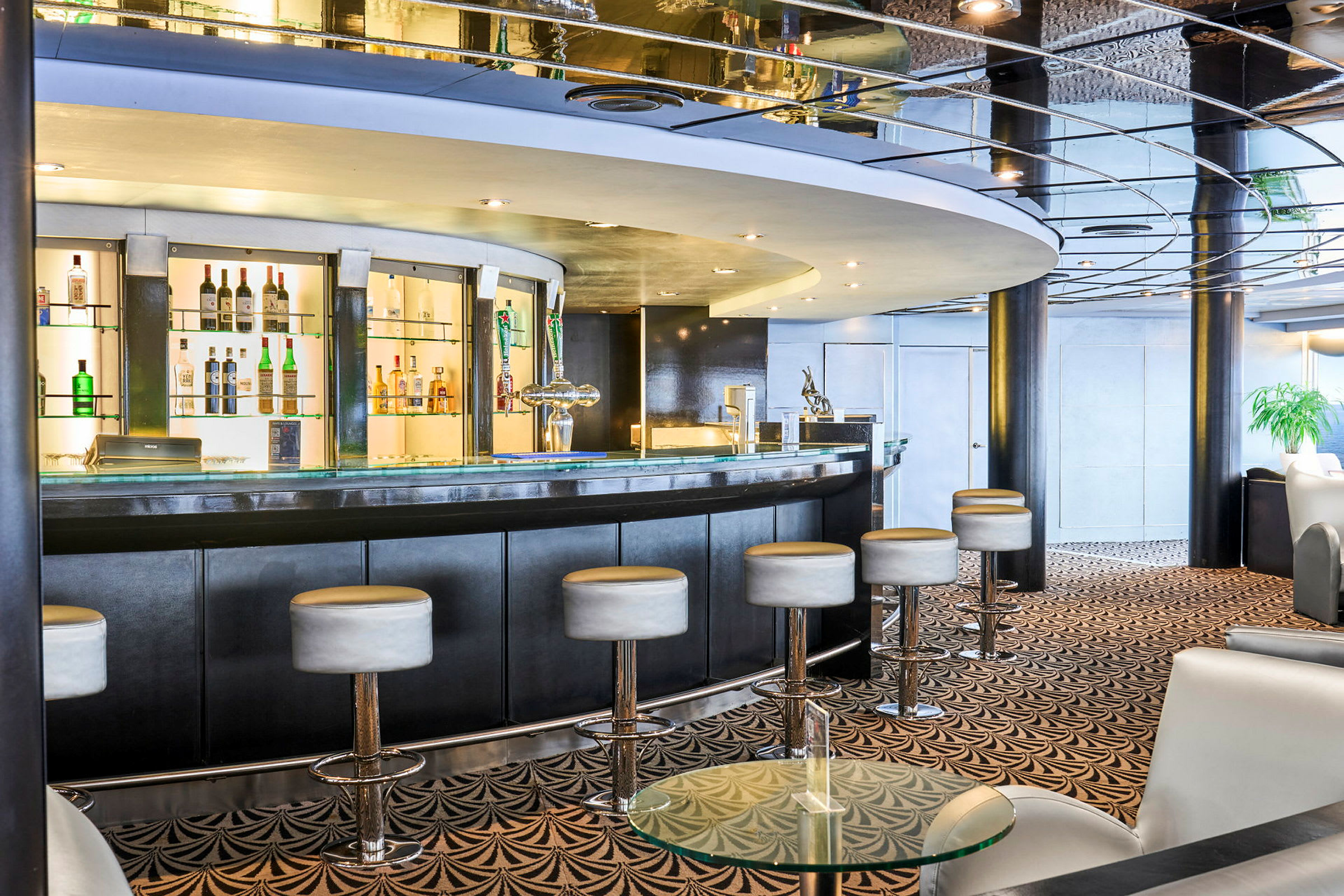Interiör av en elegant bar med en kurvad bardisk och höga sittpallar. (AI-genererad text)