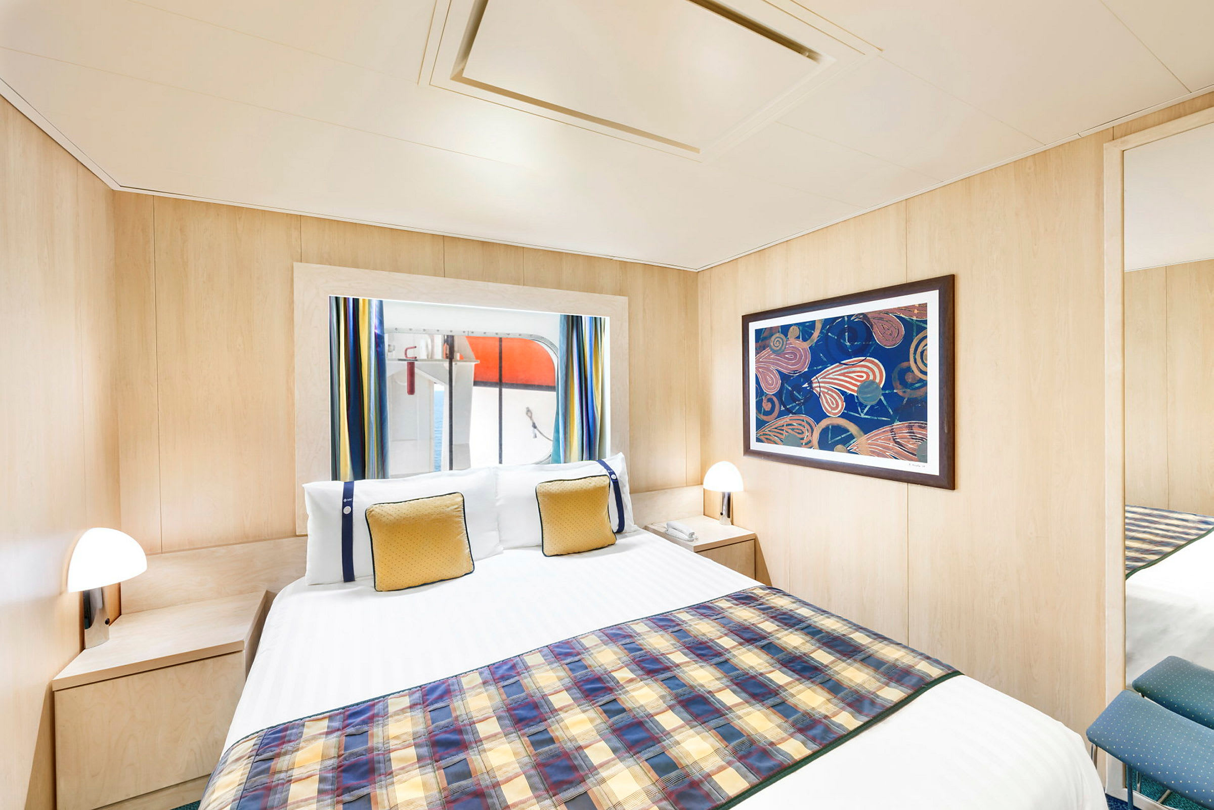 Bild på ett hotellrum med en säng, ett fönster med gardiner och en tavla på väggen. (AI-genererad text)