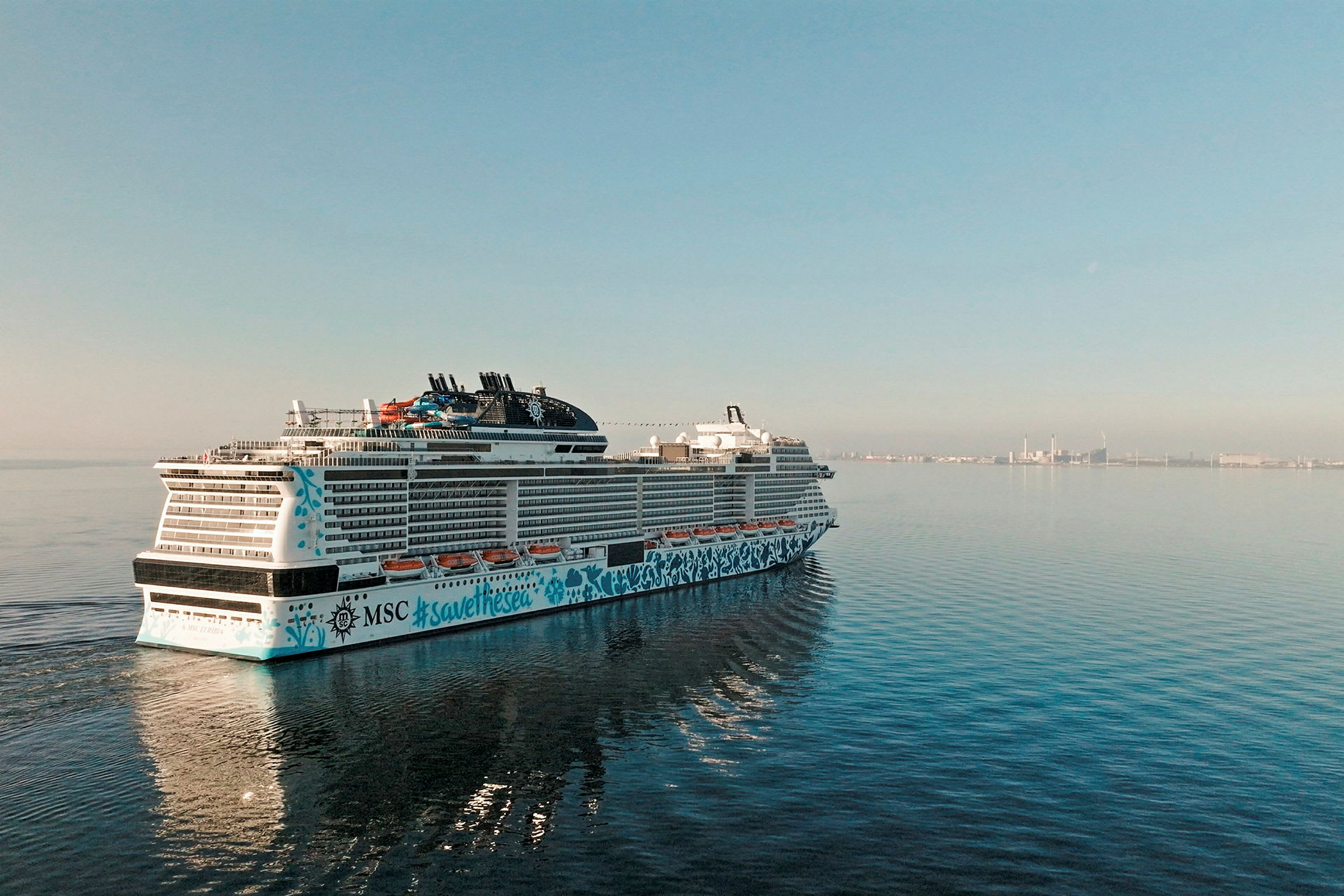Ett kryssningsfartyg på havet med en stad i bakgrunden. (AI-genererad text)