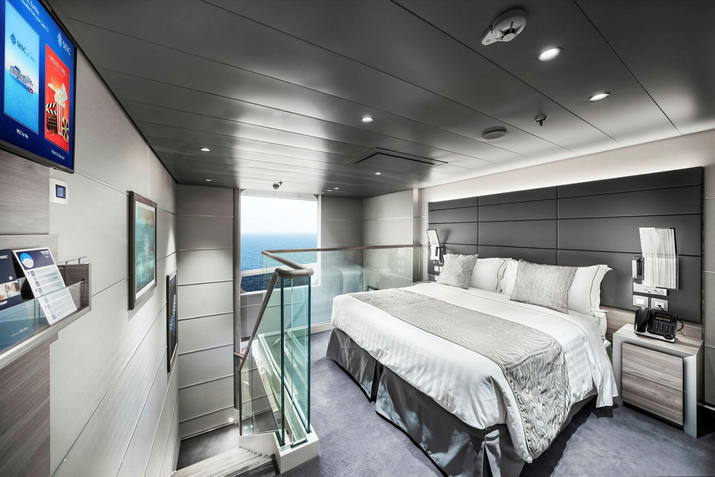 En modern hotellsvit med dubbelsäng, ljus inredning och havsutsikt. (AI-genererad text)