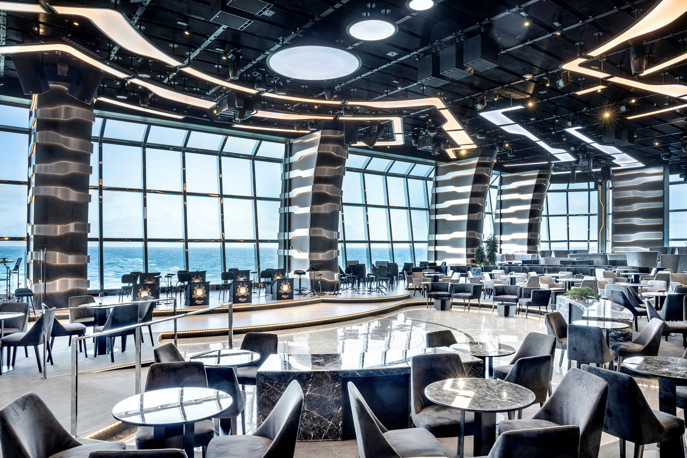 Restaurangmiljö med modern design och havsutsikt genom stora fönster. (AI-genererad text)