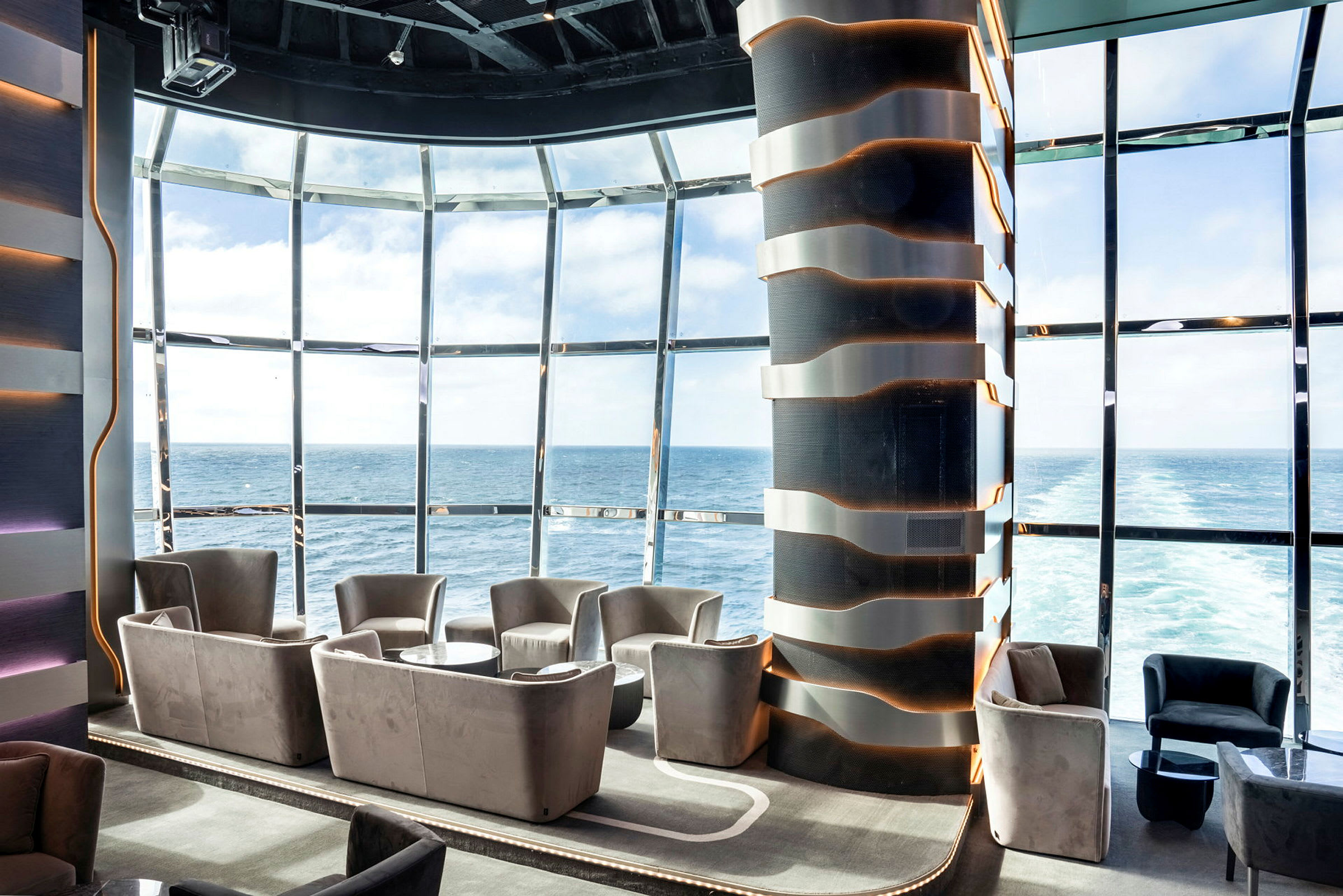 Lounge med moderna sittplatser, stora fönster med havsutsikt. (AI-genererad text)