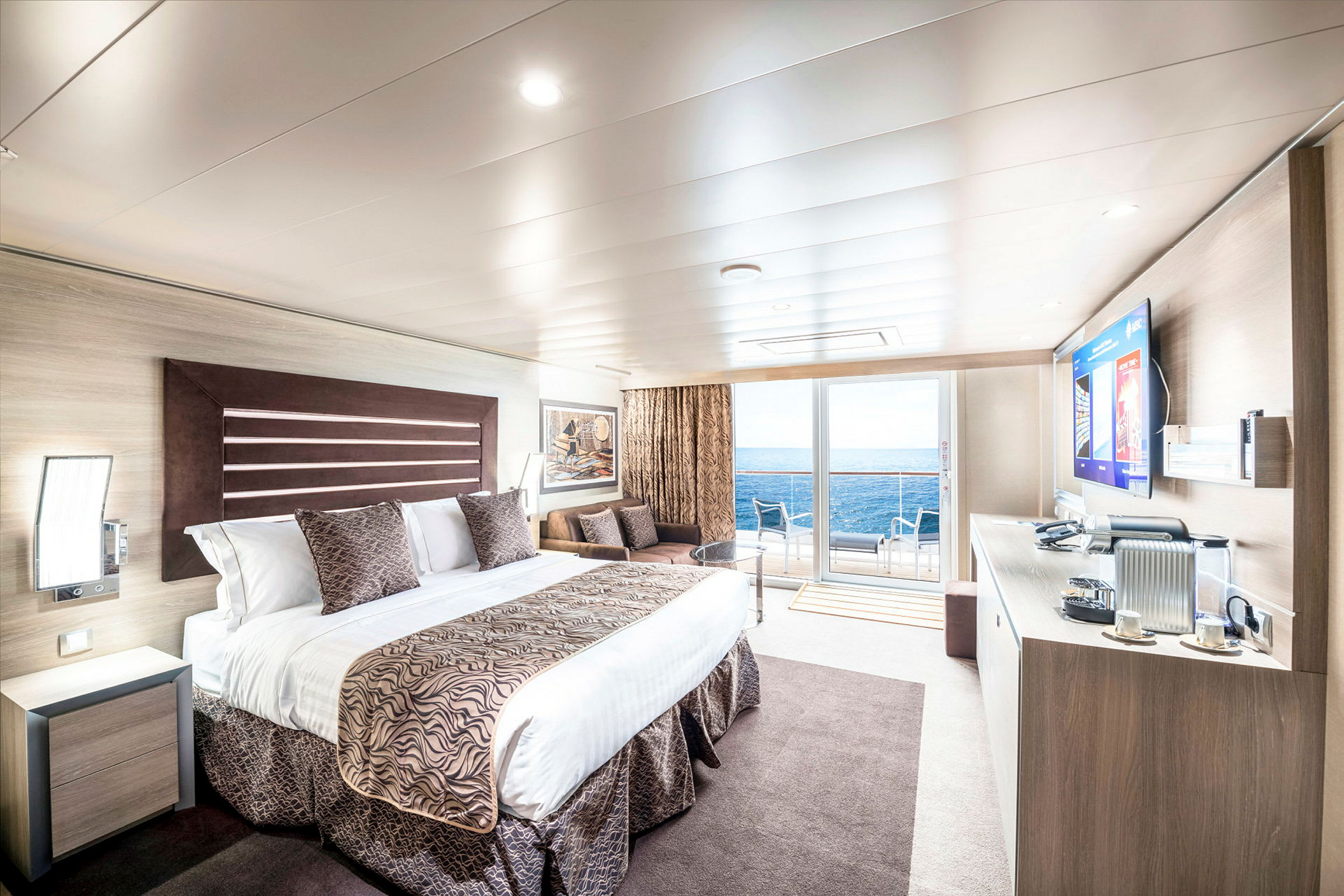 Rymligt hotellrum med modern inredning, havsutsikt och möblerad balkong. (AI-genererad text)