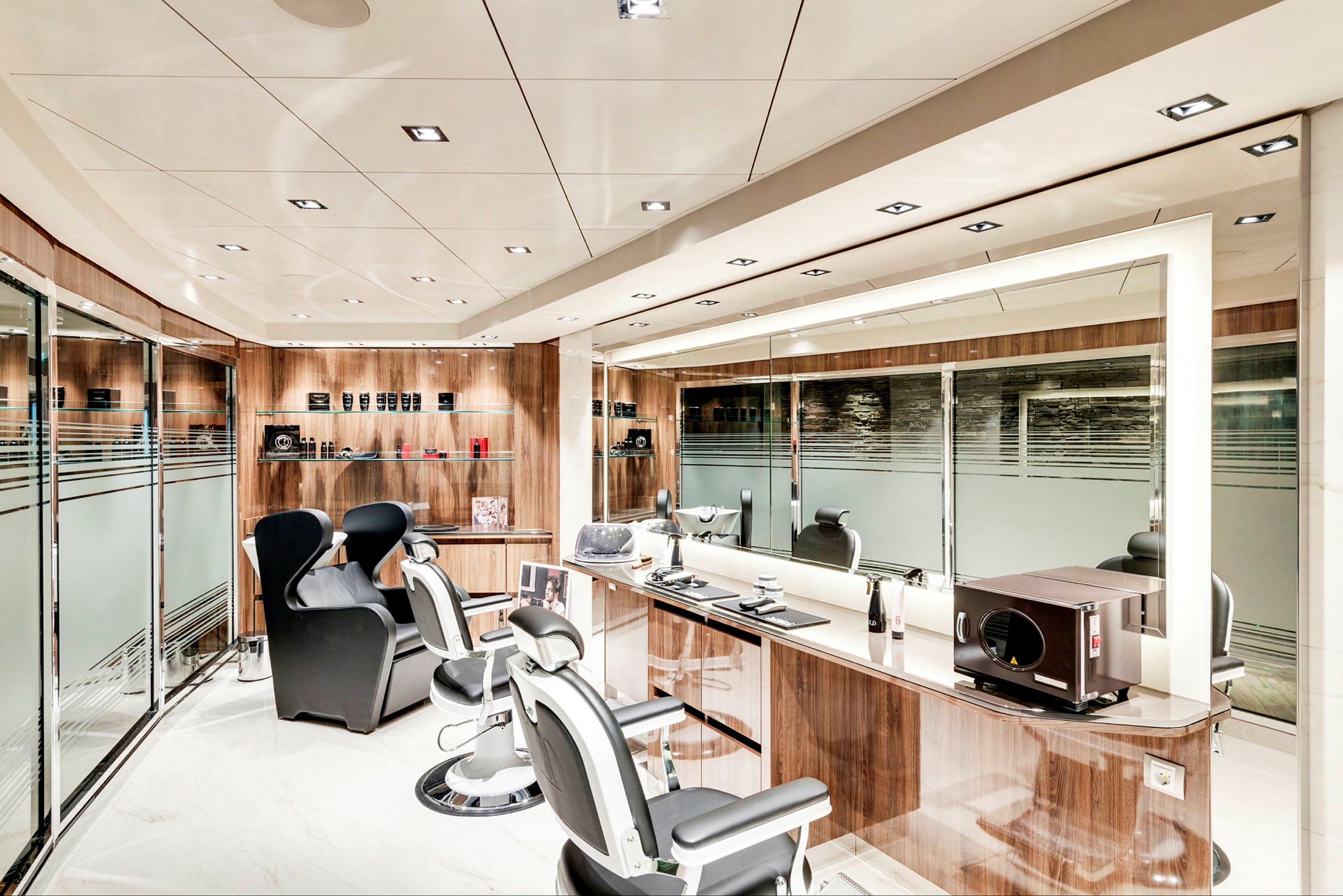 Ett modernt frisör- och barbershop med tre frisörstolar, speglar och hyllor med produkter. (AI-genererad text)