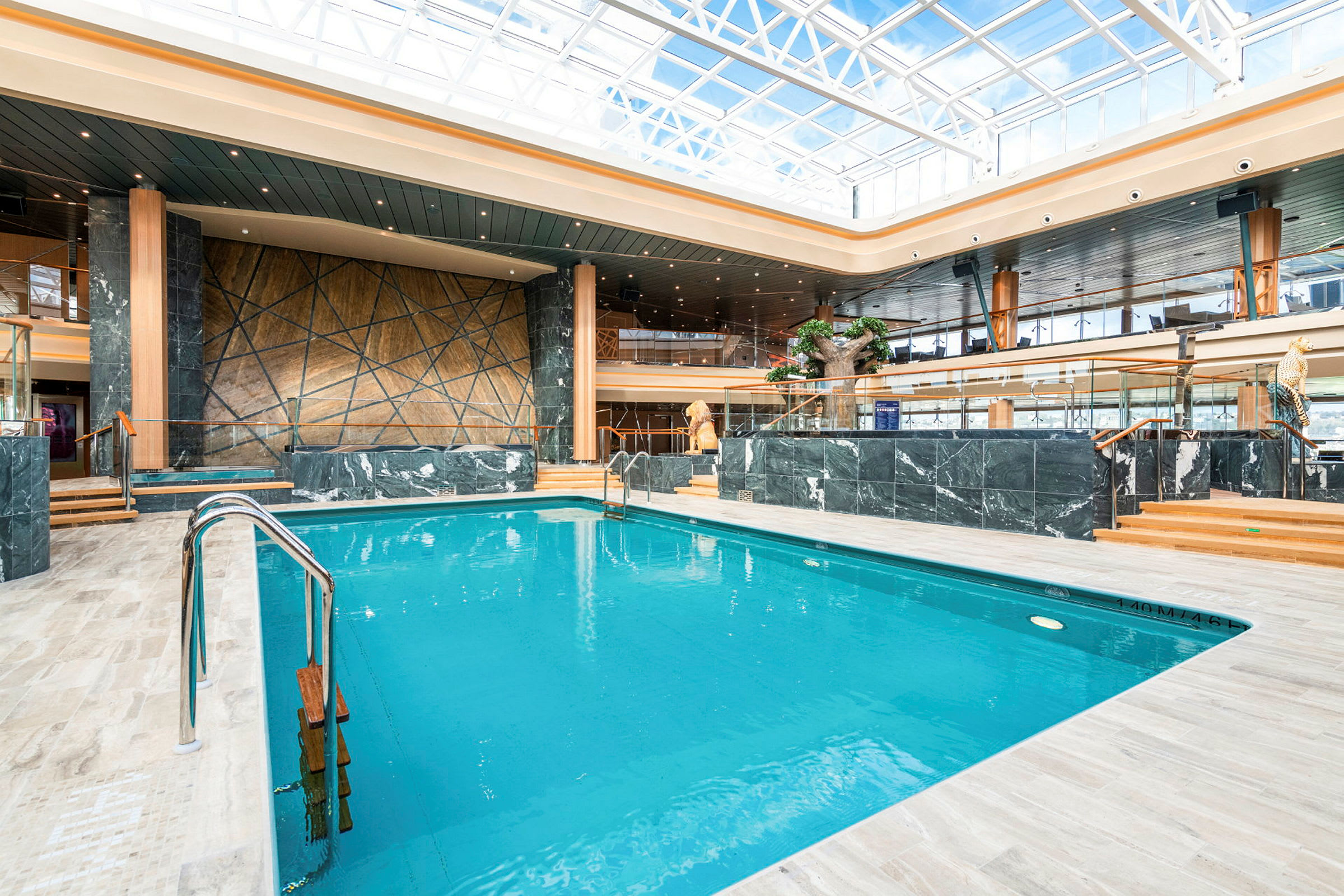 En inomhuspool med omgivande modern inredning och stora fönster. (AI-genererad text)