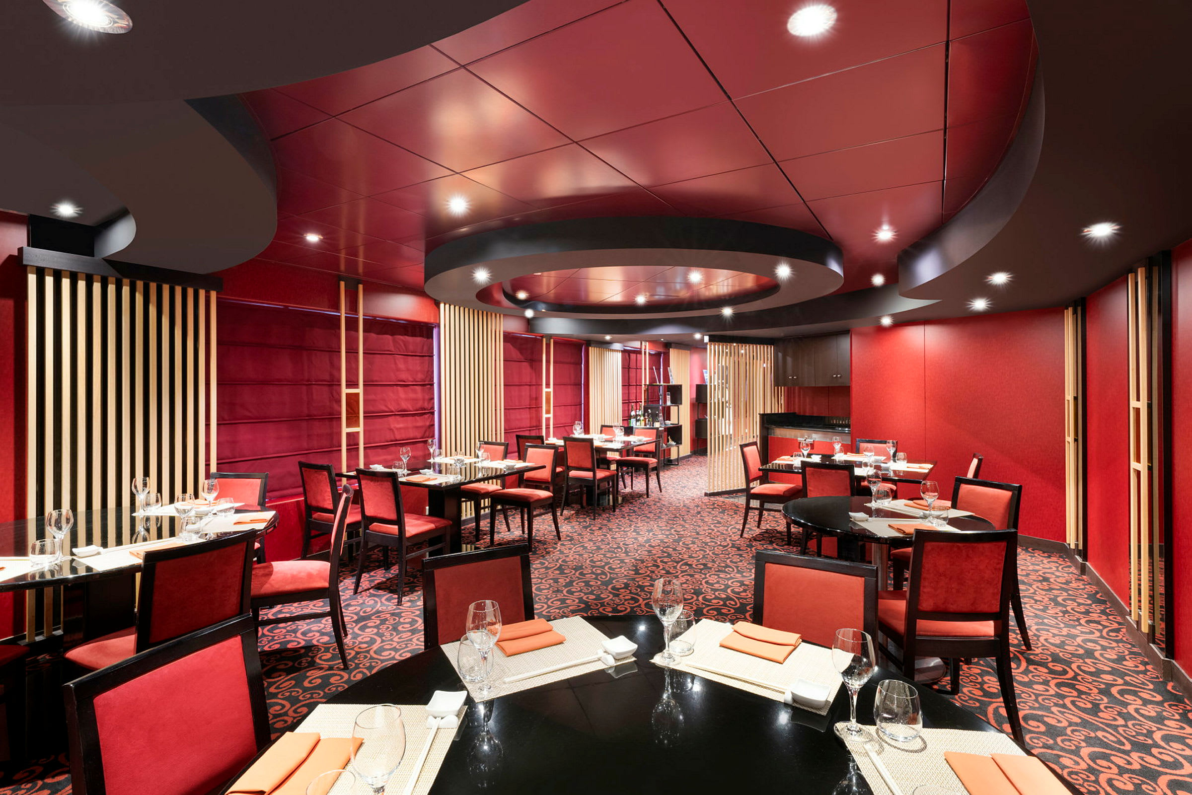 Interiör av en restaurang med röd färgtema och dukade bord. (AI-genererad text)