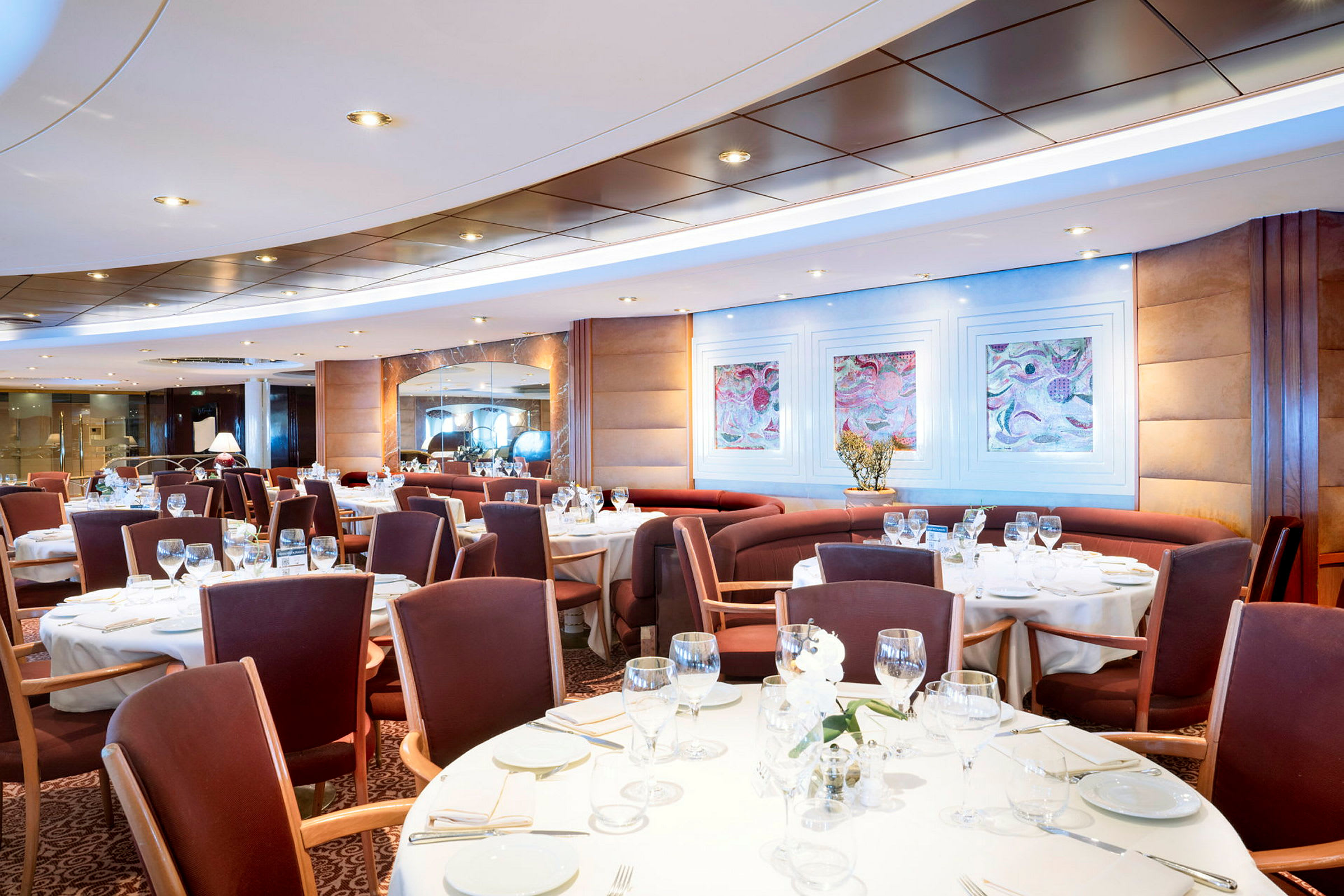 En elegant restaurang med dukade bord och stolar runt dem. (AI-genererad text)