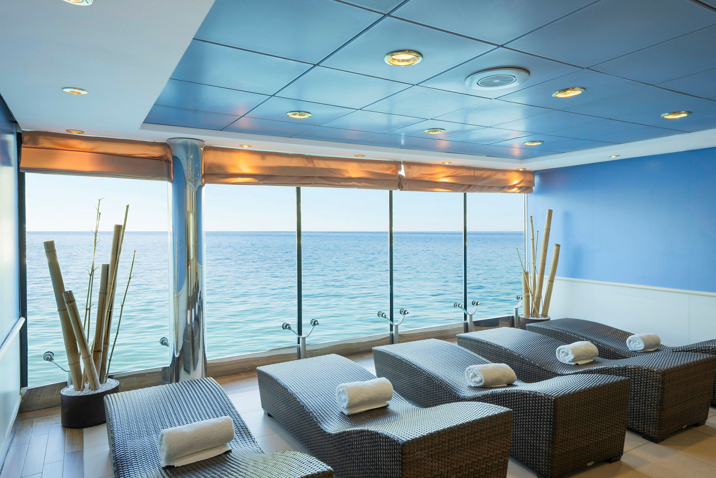 Spa-lounge med utsikt över havet, solstolar de är klädda med handdukar. (AI-genererad text)