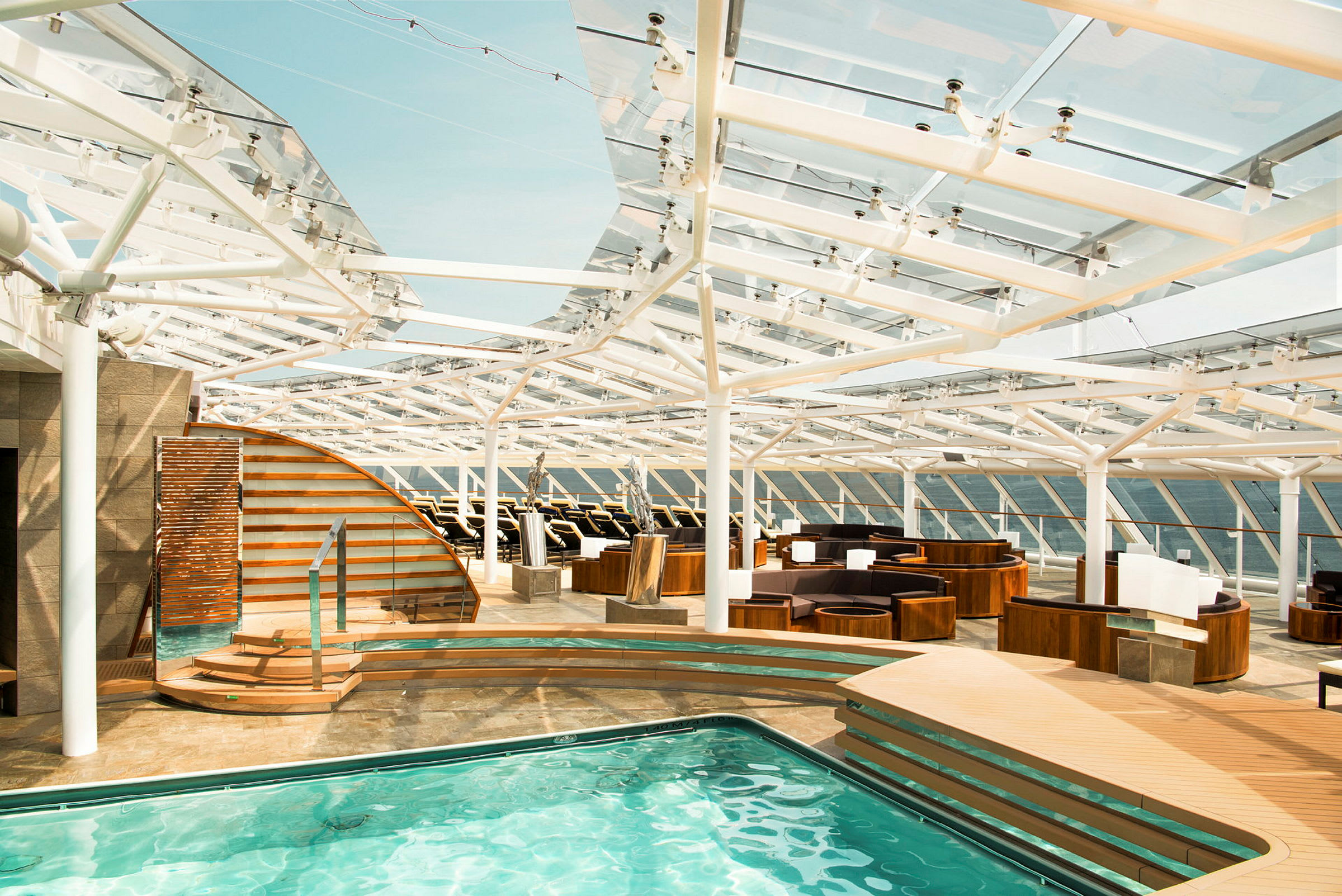 En pool med sittplatser och en modern arkitektonisk takstruktur. (AI-genererad text)