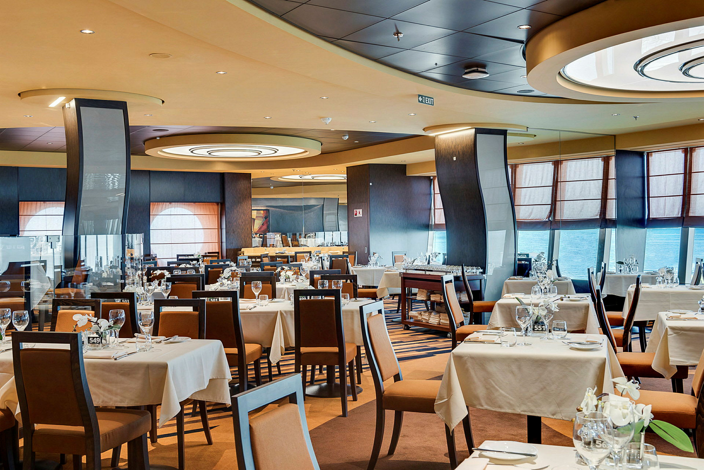 Interiör av en rymlig restaurang med dukade bord och stolar. (AI-genererad text)