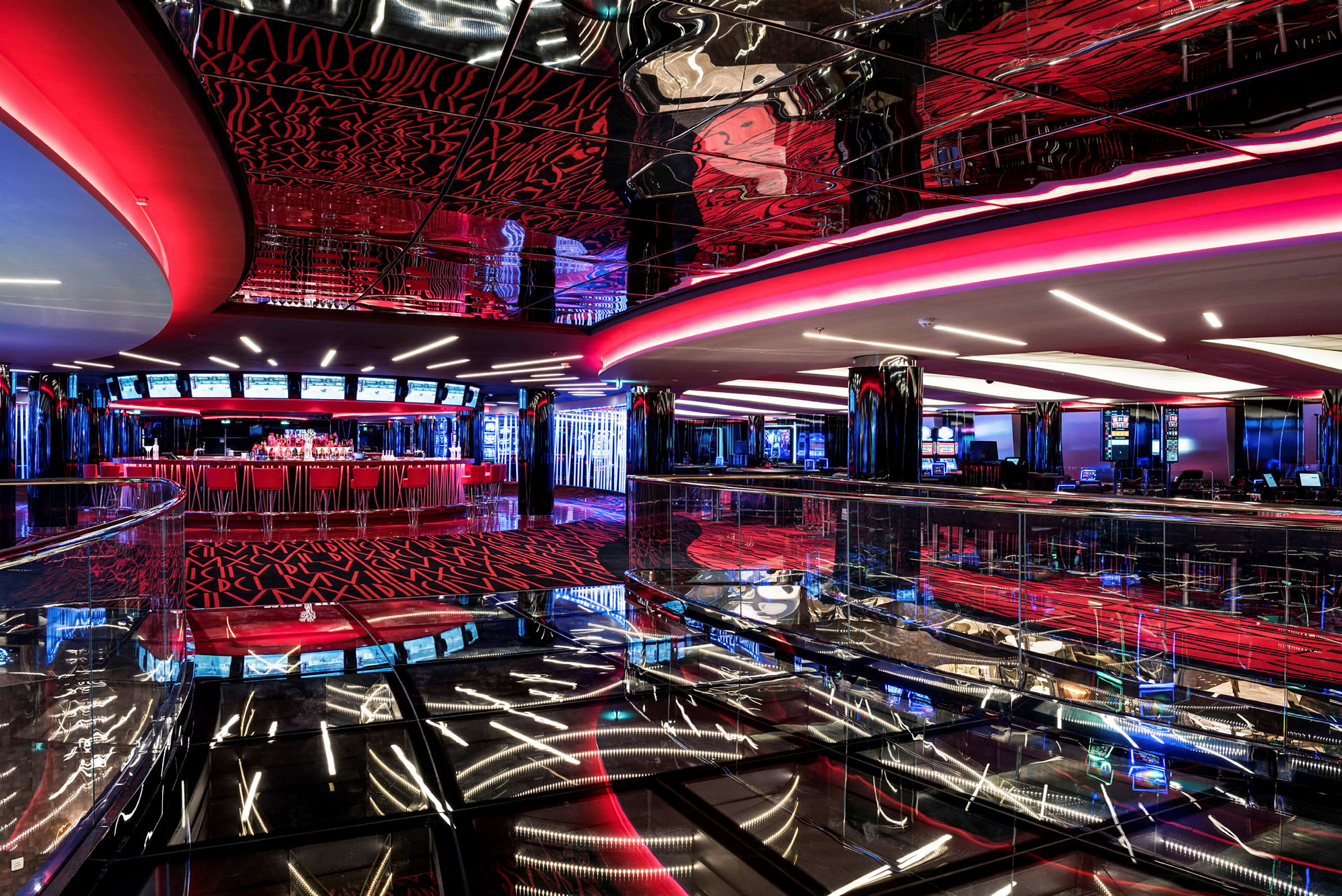 Ett casinokomplex med moderna interiörer i rött och svart, speglande ytor och ljusdekorationer. (AI-genererad text)