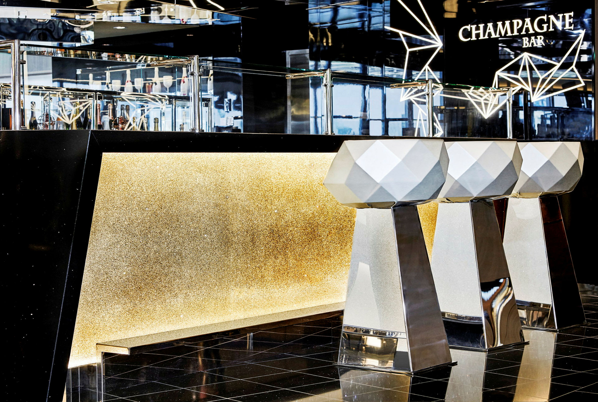 En champagnebar med moderna designstolar och glittrande detalj på bardisken. (AI-genererad text)