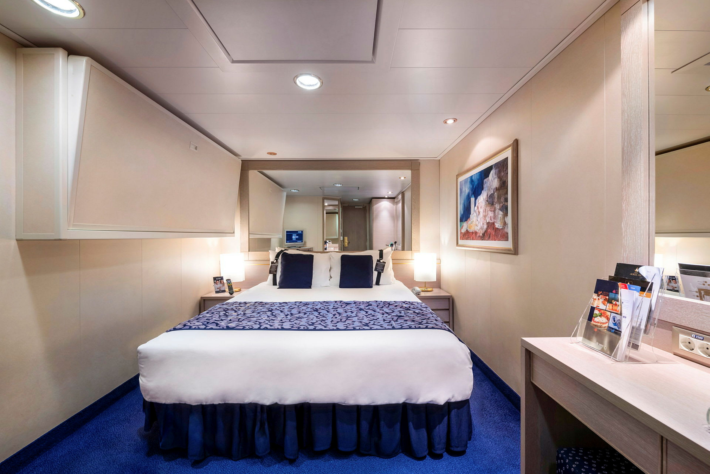 Bild av ett modernt hotellrum med en dubbelsäng, blå matta och väggdekoration. (AI-genererad text)