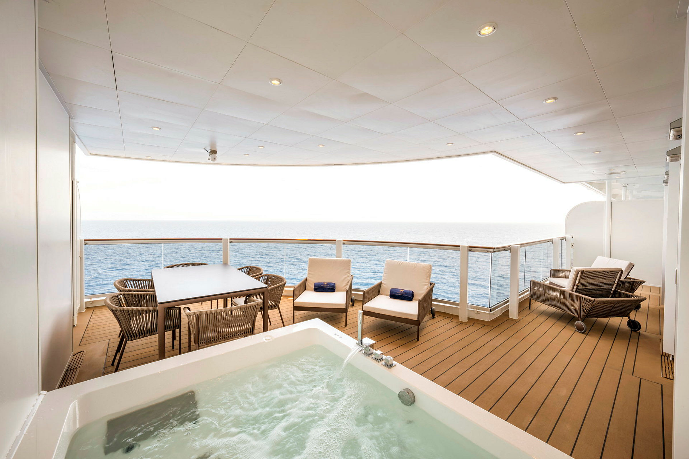 Bild av en balkong med havsutsikt, utrustad med möbler och en jacuzzi. (AI-genererad text)
