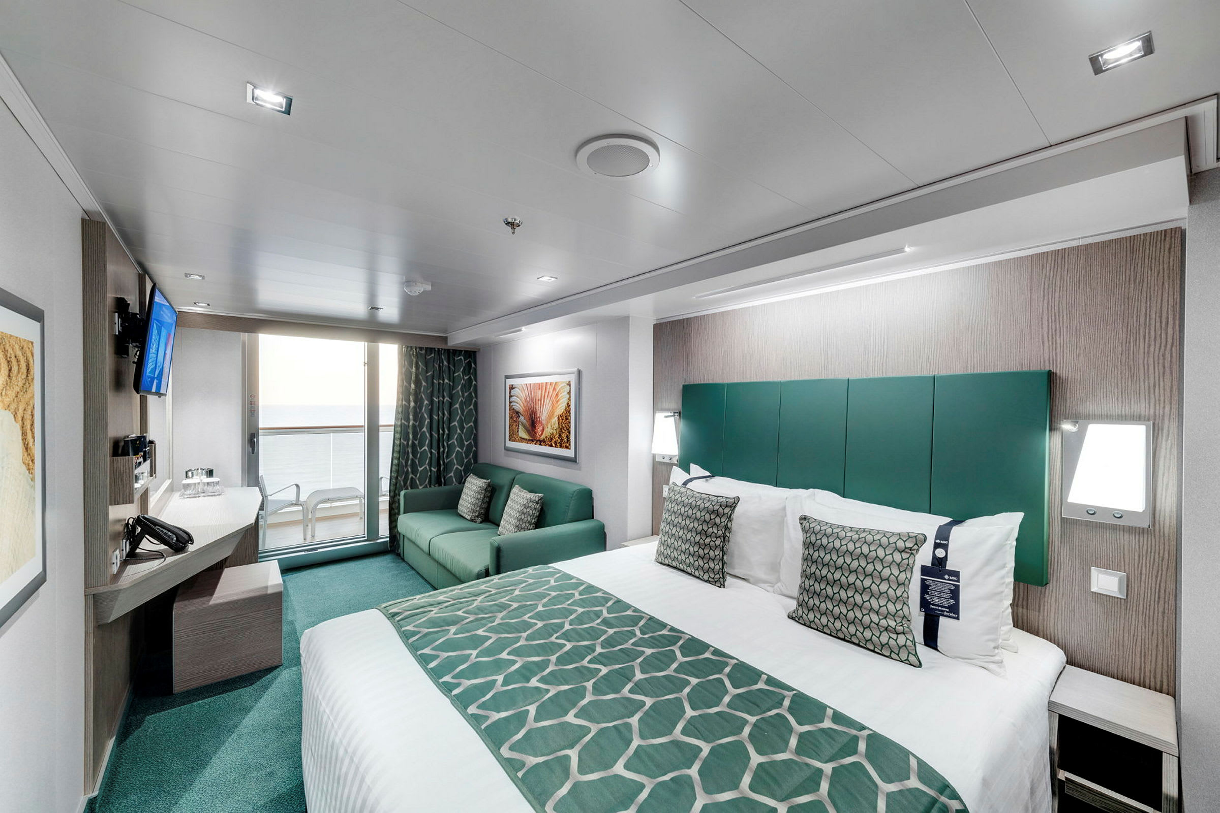 Ett modernt hotellrum med säng, soffa och balkong med utsikt. (AI-genererad text)