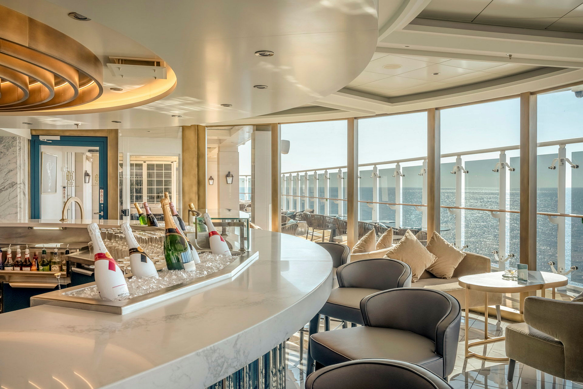 En ljus bar med bord och stolar samt utsikt över havet. (AI-genererad text)