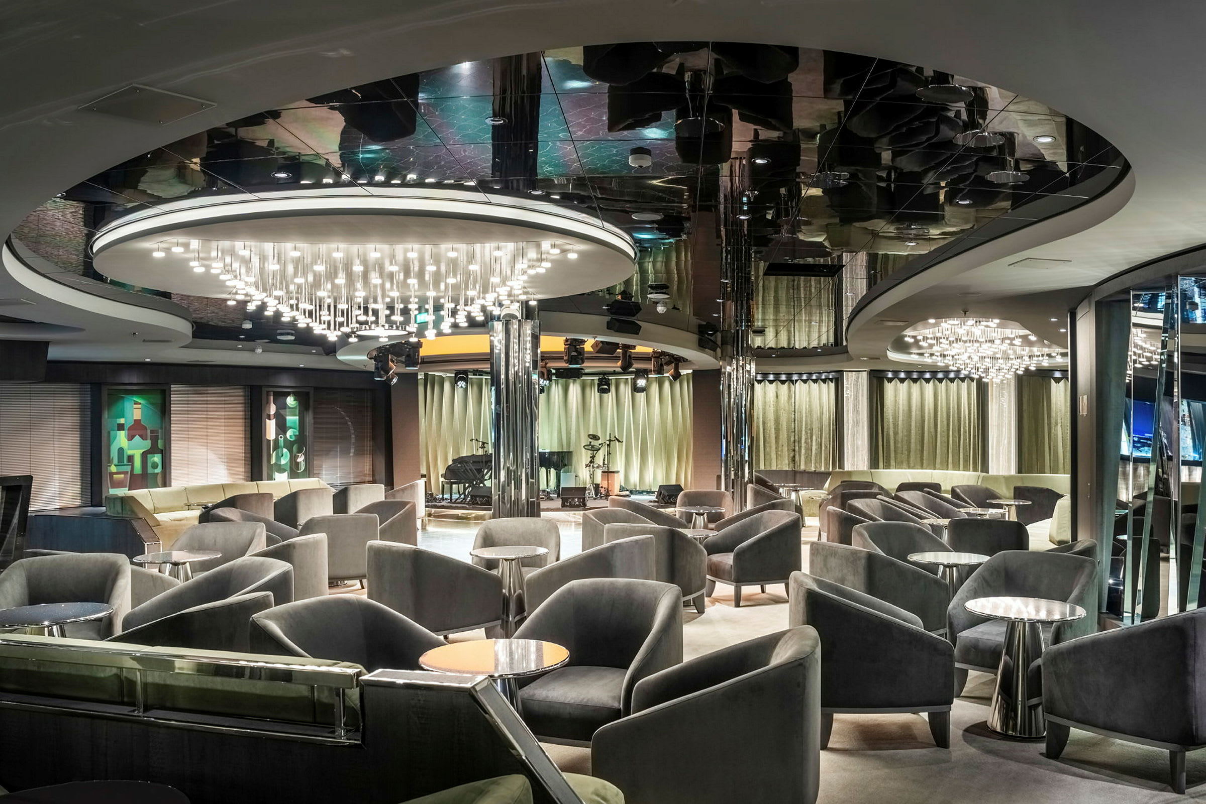 Lounge med bekväma stolar, små bord och hängande ljuskronor. (AI-genererad text)