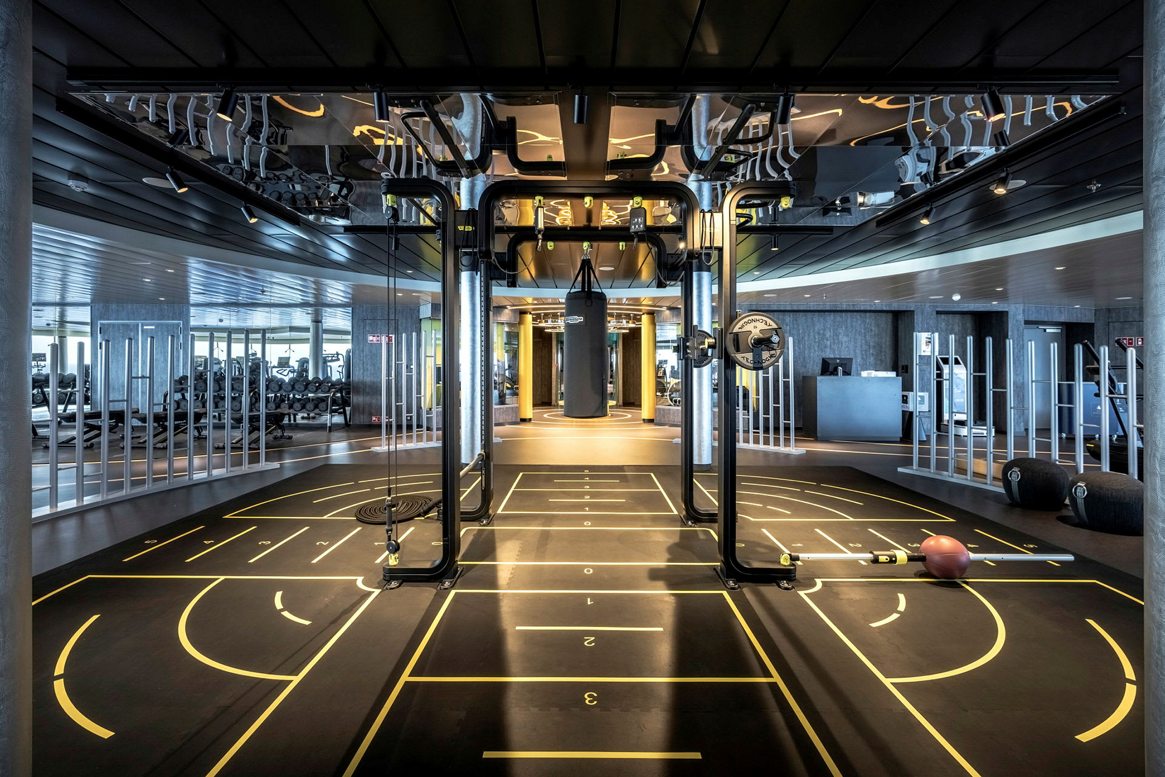 Ett modernt gym med träningsutrustning och markerade ytor på golvet. (AI-genererad text)