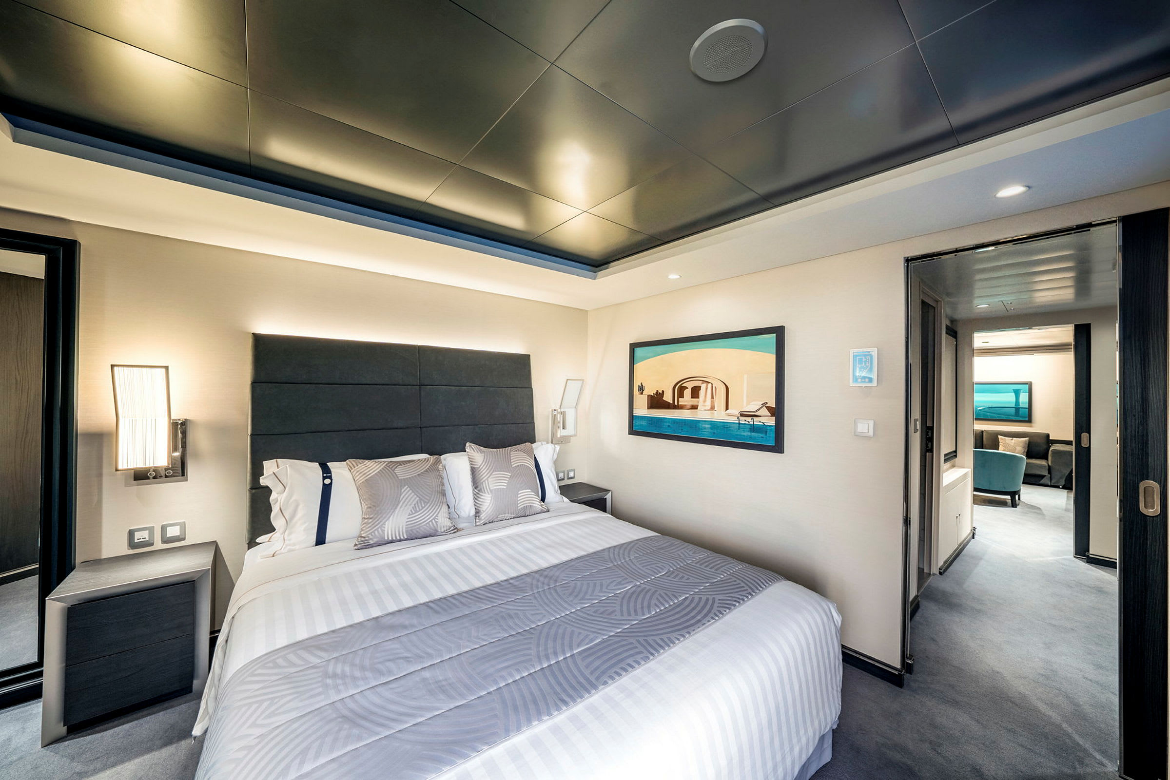 Hotellrum med säng och dekorativt konstverk på väggen. (AI-genererad text)