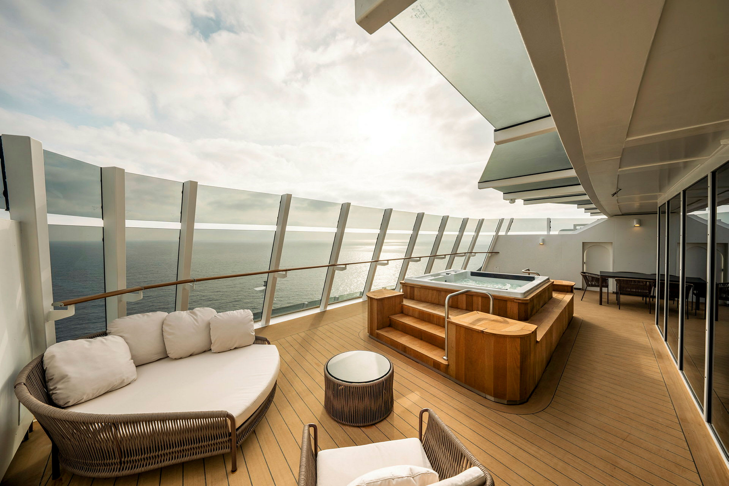 Privat terrass med jacuzzi, sittmöbler och utsikt över havet. (AI-genererad text)