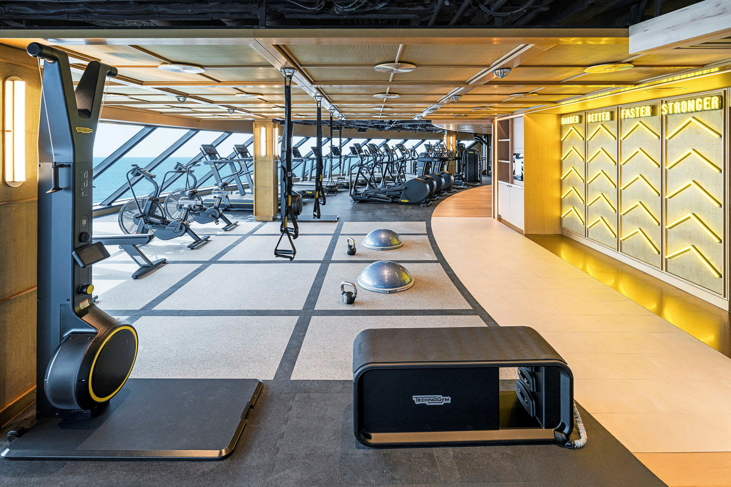 Gym med träningsmaskiner, fria vikter och balansbollar. Stora fönster släpper in dagsljus. (AI-genererad text)