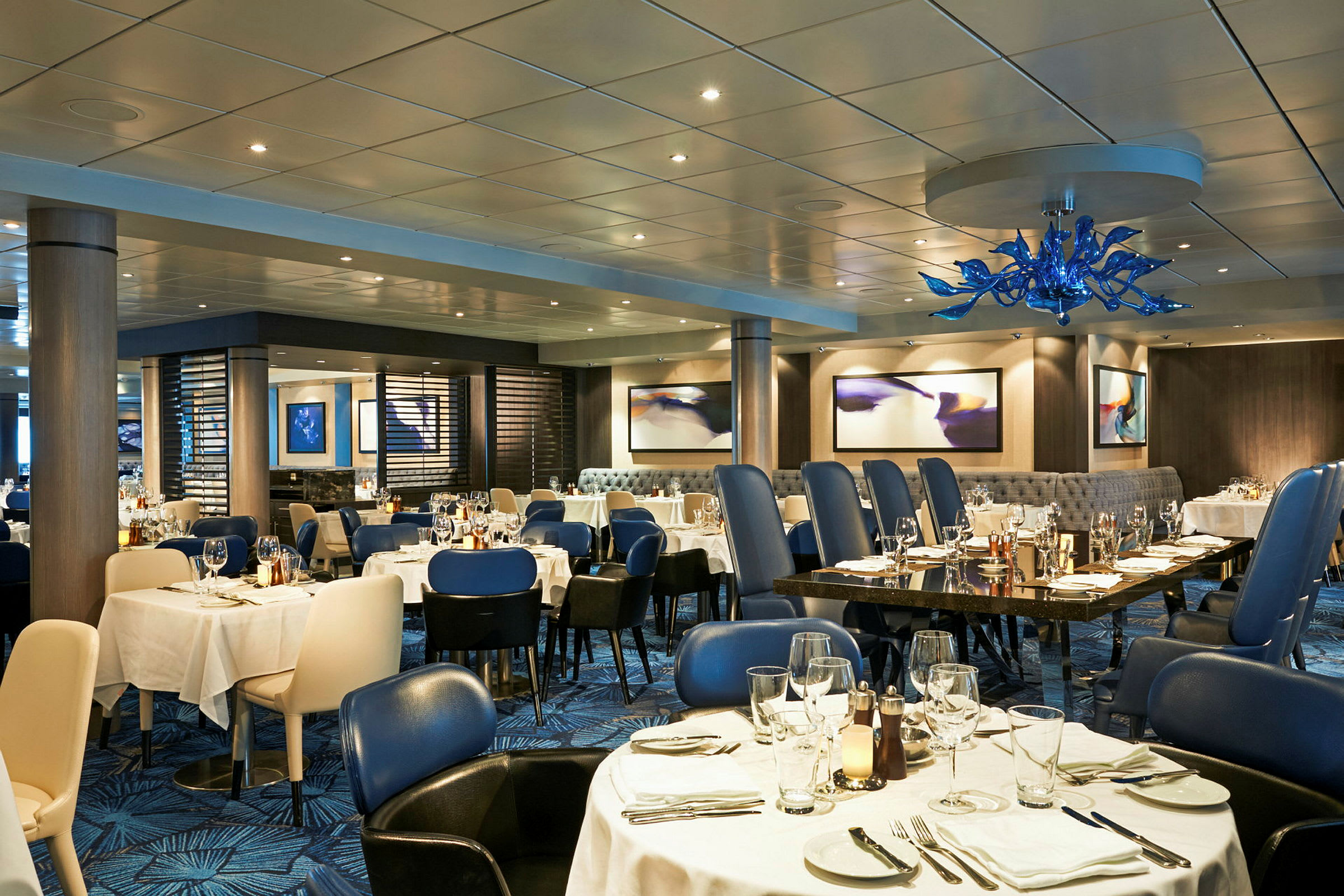 En elegant restaurang med dukade bord och blå stolar. (AI-genererad text)
