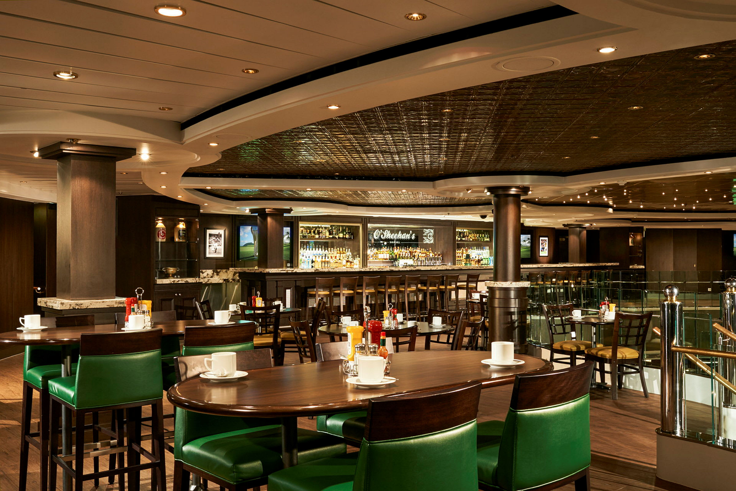 Bild av en restaurang med gröna stolar, bord och en bar i bakgrunden. (AI-genererad text)