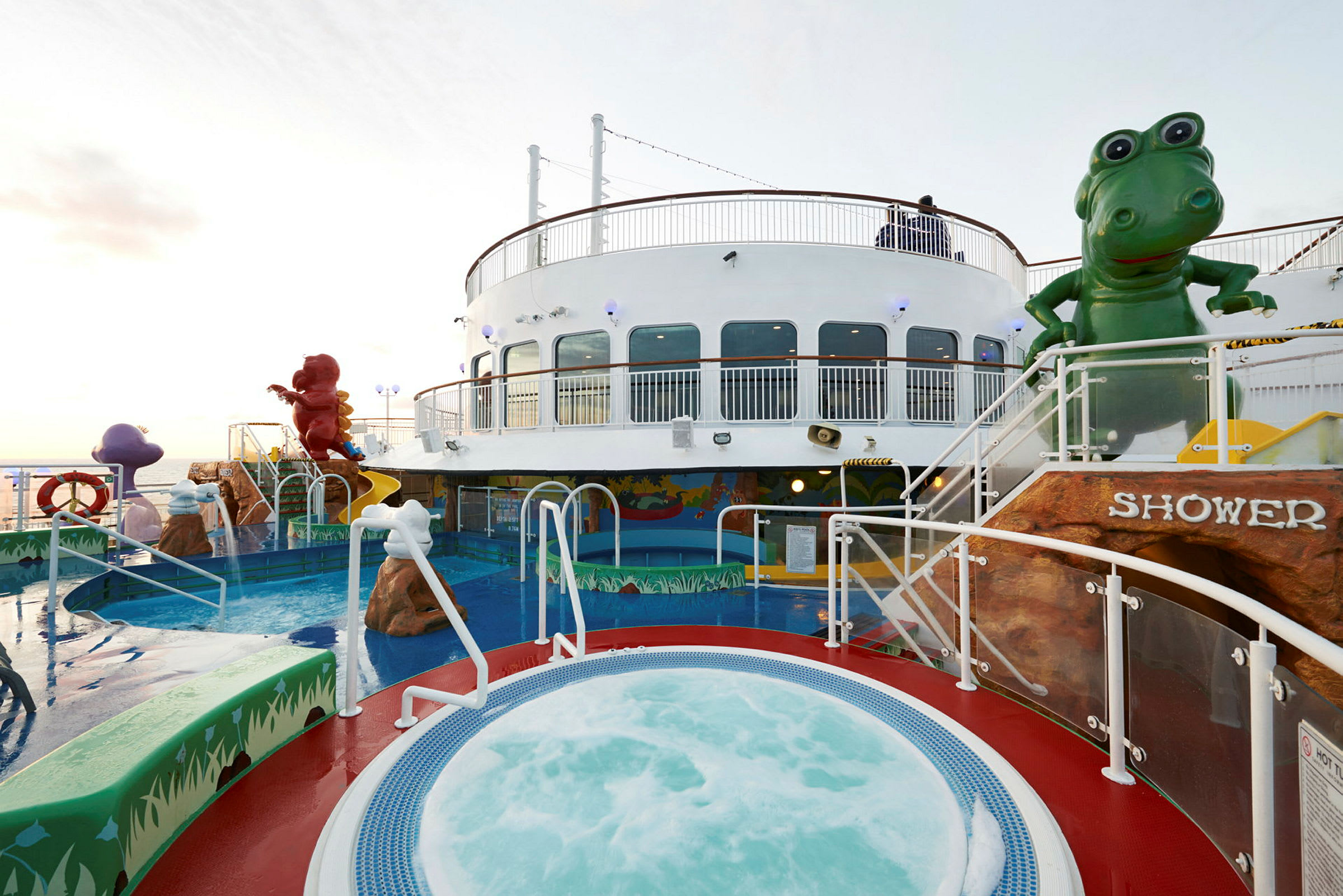 Utsikt över en pool och jacuzzi på ett fartyg, omgiven av djurkanor och lekattraktioner. (AI-genererad text)