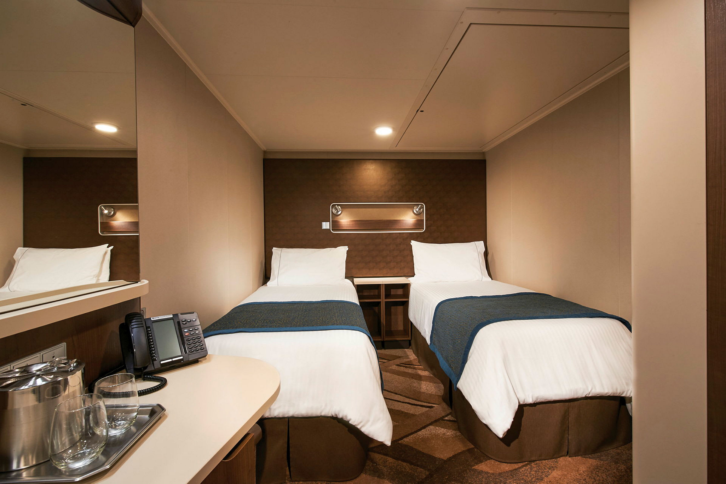 Ett hotellrum med två enkelsängar och en liten avlastningsyta. (AI-genererad text)