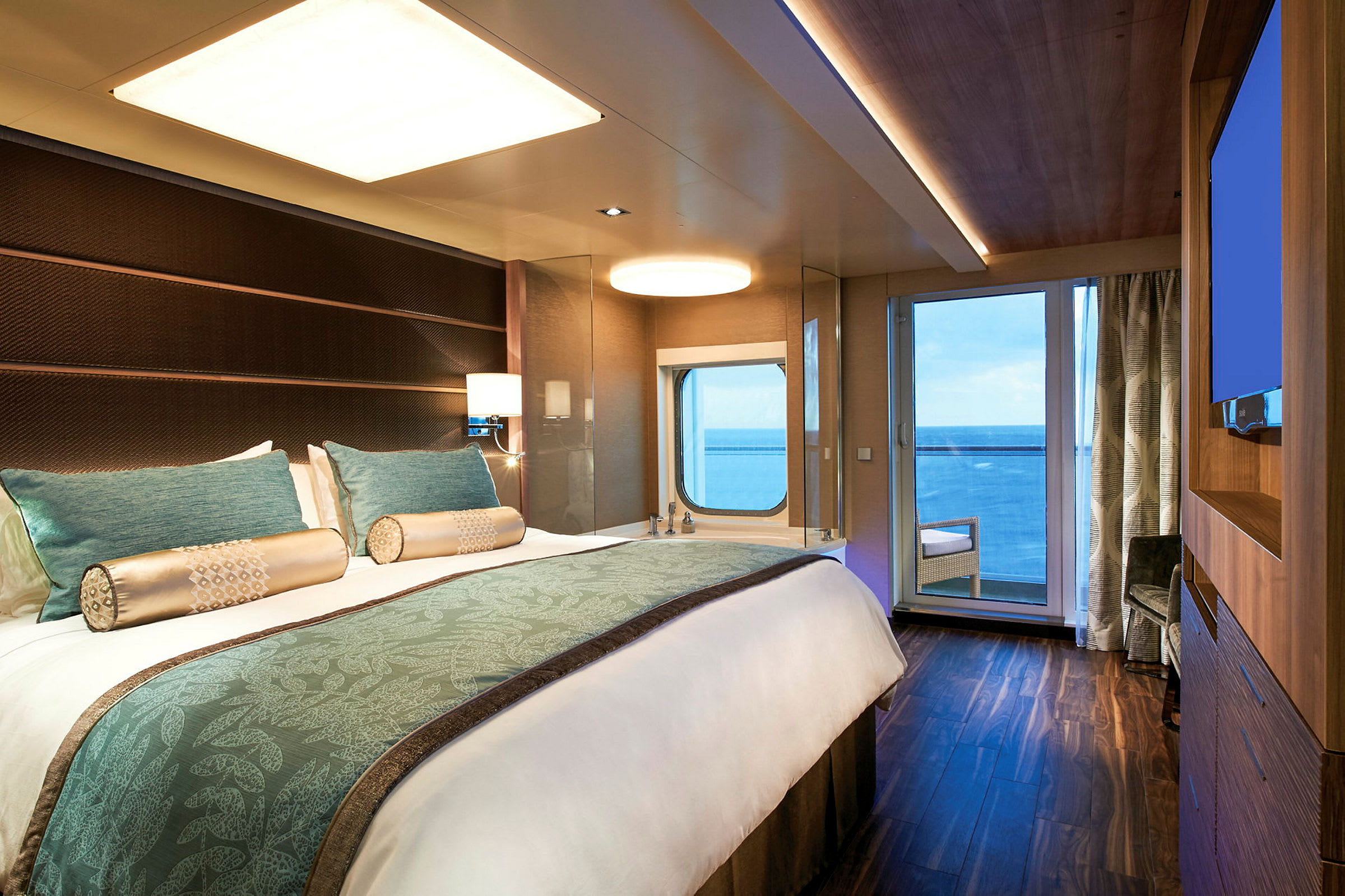 Bild av ett hotellrum med en bäddad dubbelsäng, fönster och balkong med utsikt över havet. (AI-genererad text)