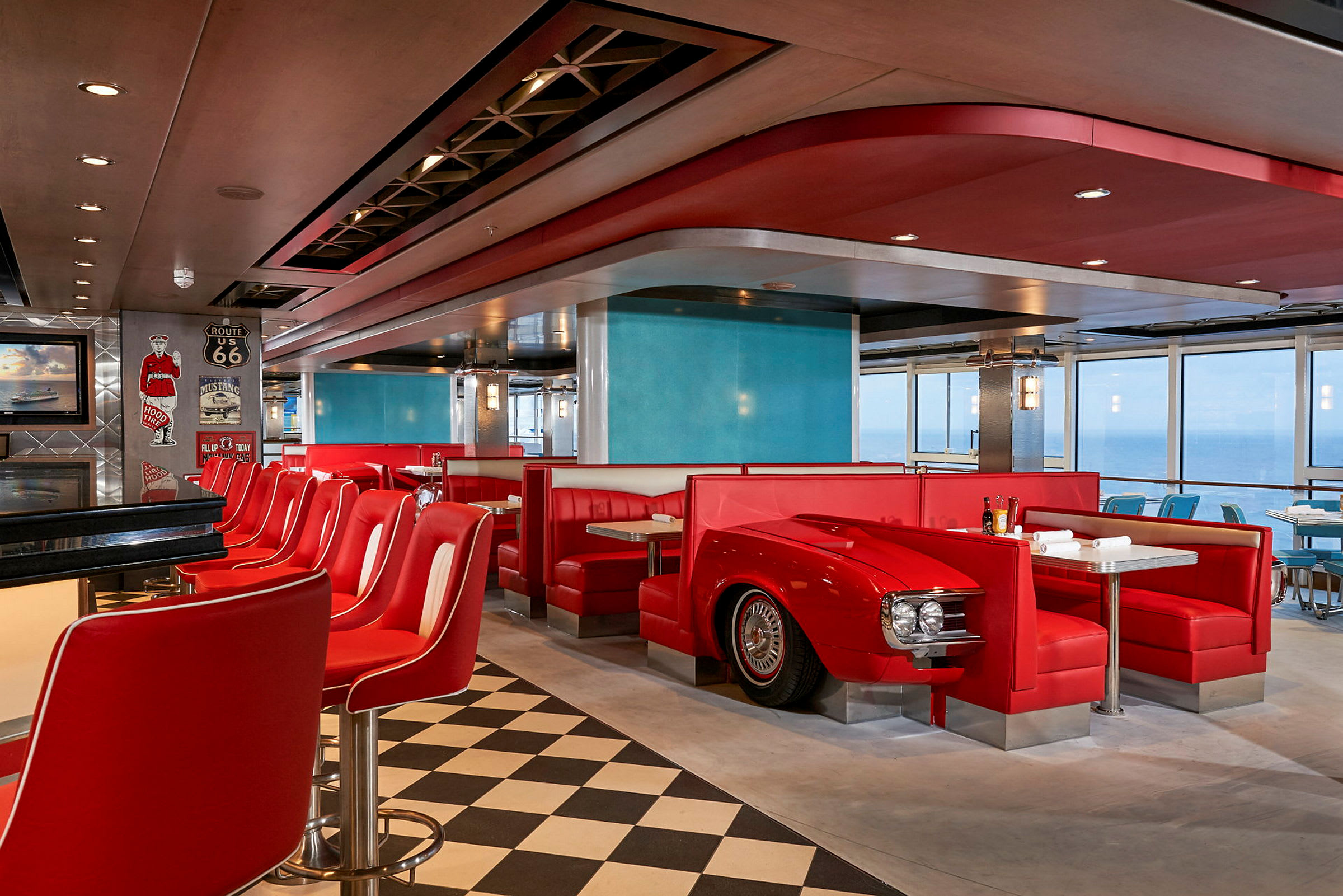 Interiör av en amerikansk diner med röda soffor och en bardisk omgiven av röda stolar. (AI-genererad text)