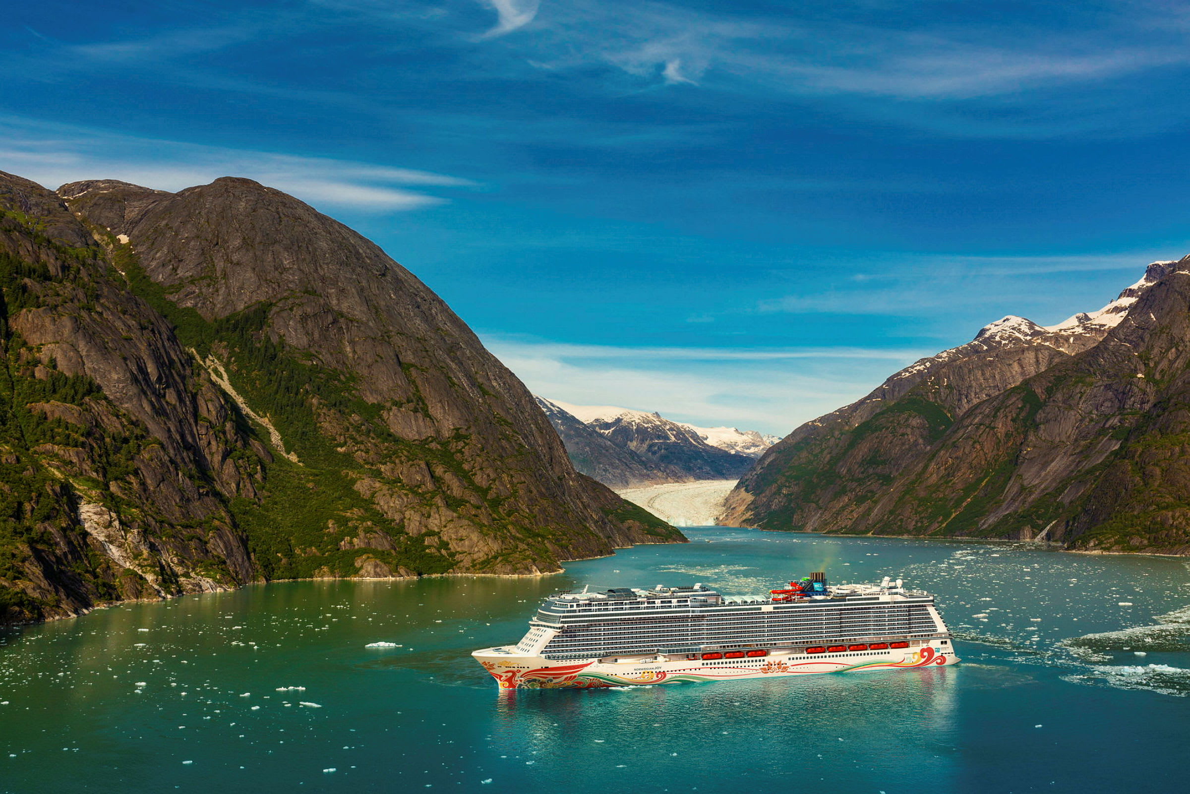 Kryssningsfartyg i fjord med omgivande berg och glaciär i bakgrunden. (AI-genererad text)