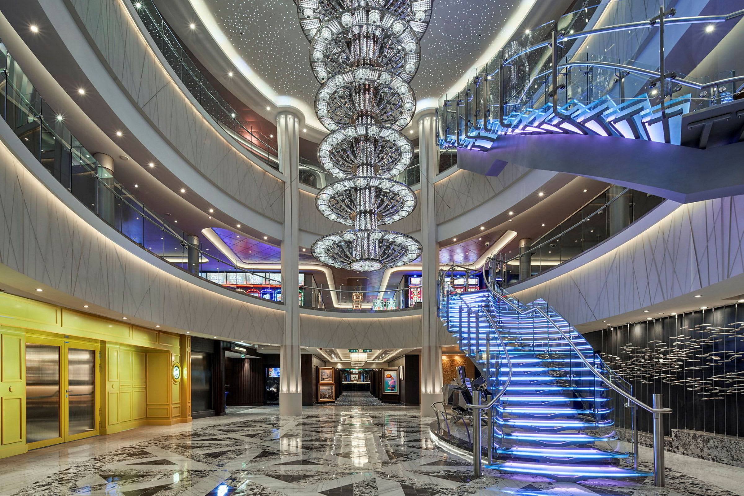 Interiör av en modern och elegant hall med en glittrande ljuskrona och en upplyst trappa. (AI-genererad text)