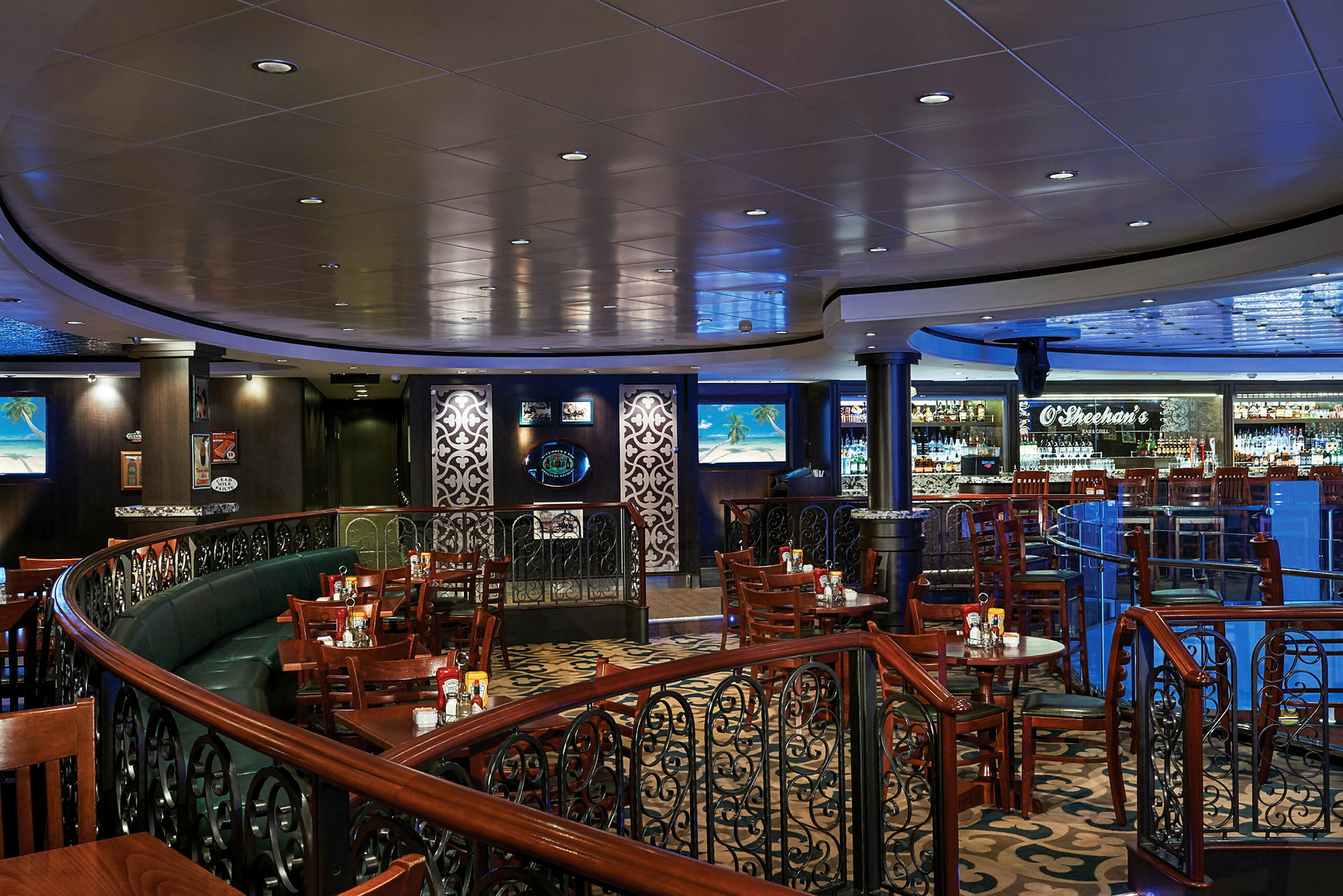 Interiör från en restaurang med träbord och stolar, samt en bar och dekorativa räcken. (AI-genererad text)