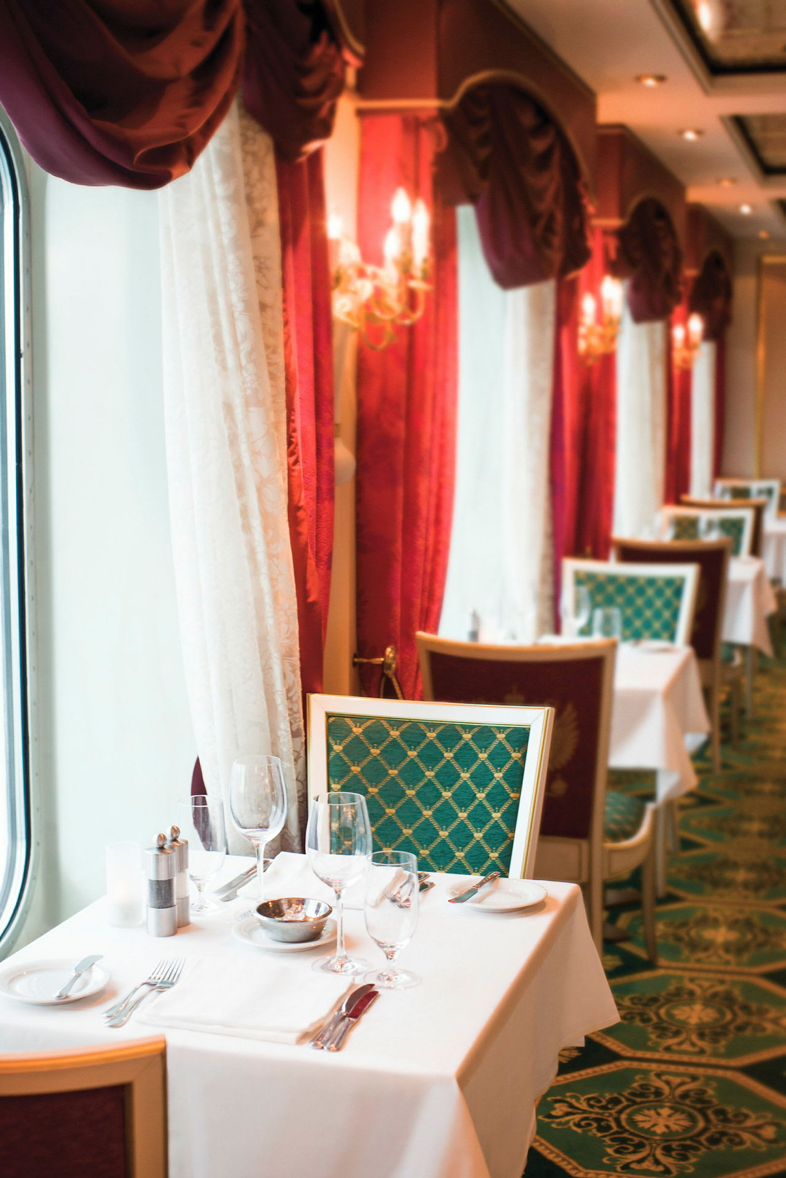 En elegant restaurang med dukade bord och röda gardiner. (AI-genererad text)