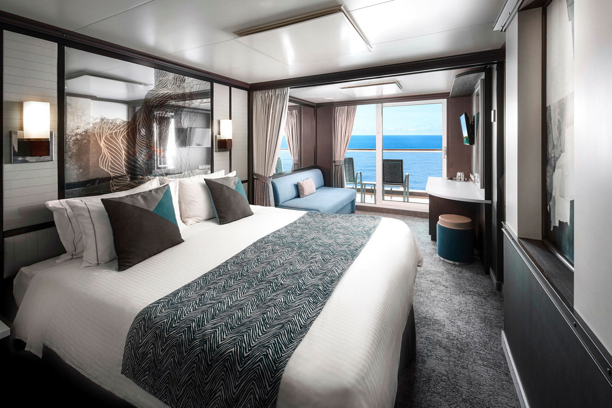 Interiör av ett modernt hotellrum med en stor säng och en utsikt mot havet från balkongen. (AI-genererad text)