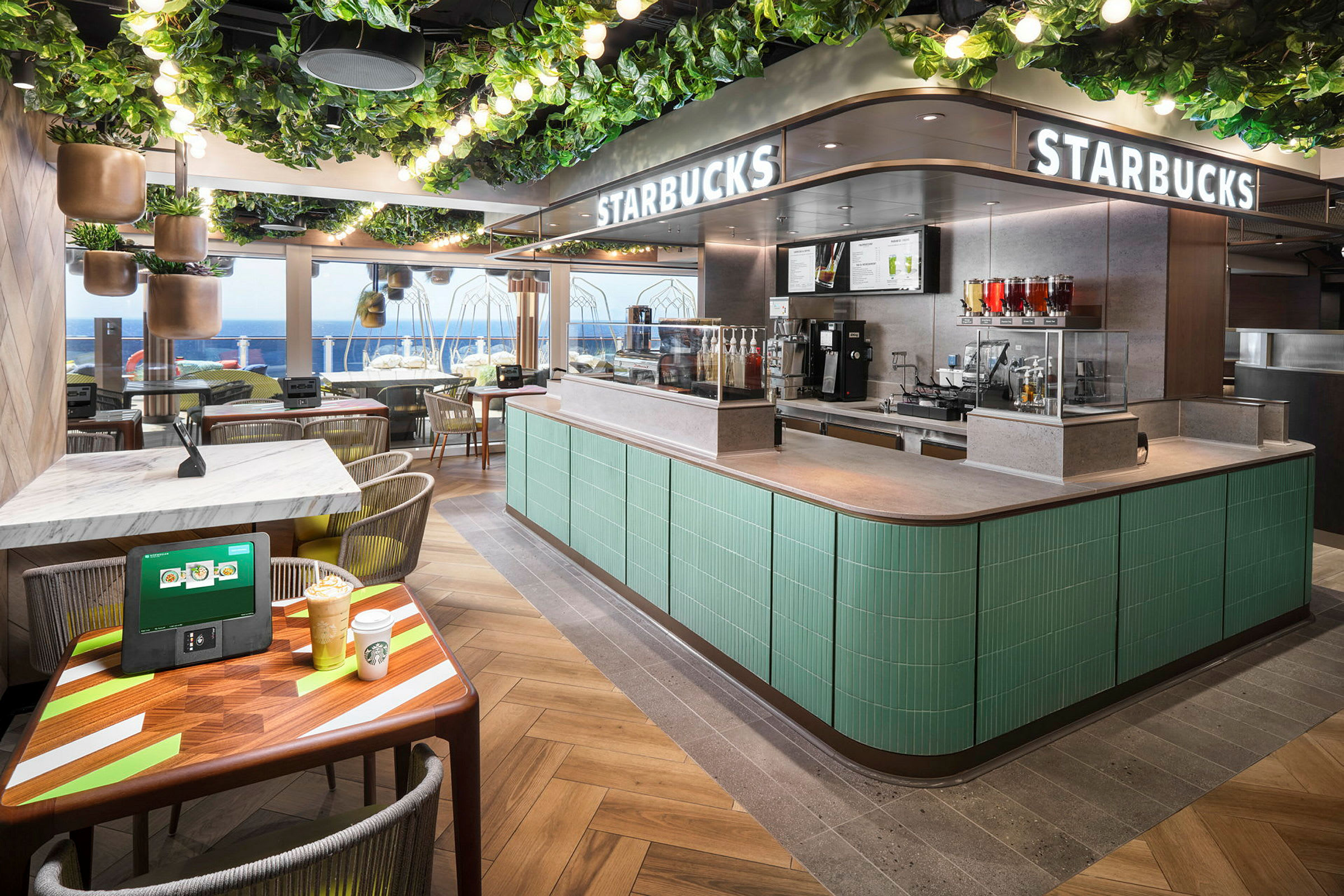 En Starbucks-butik med havsutsikt, grön inredning och sittplatser. (AI-genererad text)