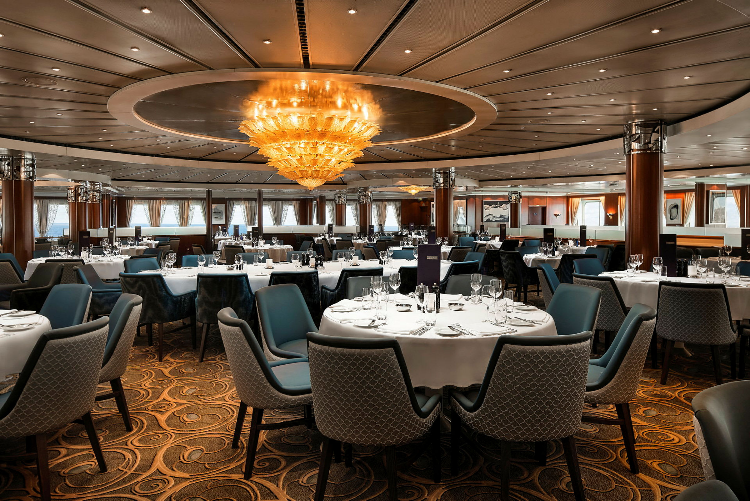 En elegant restaurang med dukade bord och en stor taklampa. (AI-genererad text)