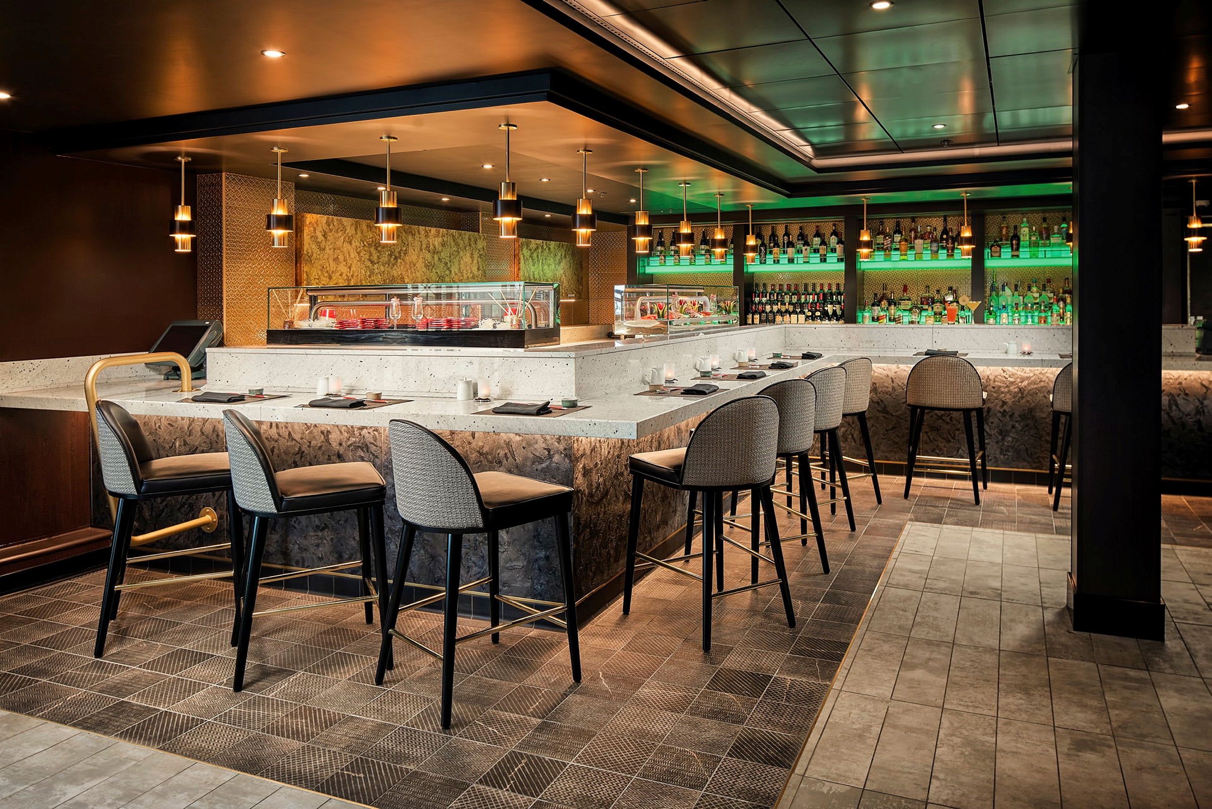 En modern bar med höga stolar, skarpa belysningar och flaskor på hyllorna. (AI-genererad text)