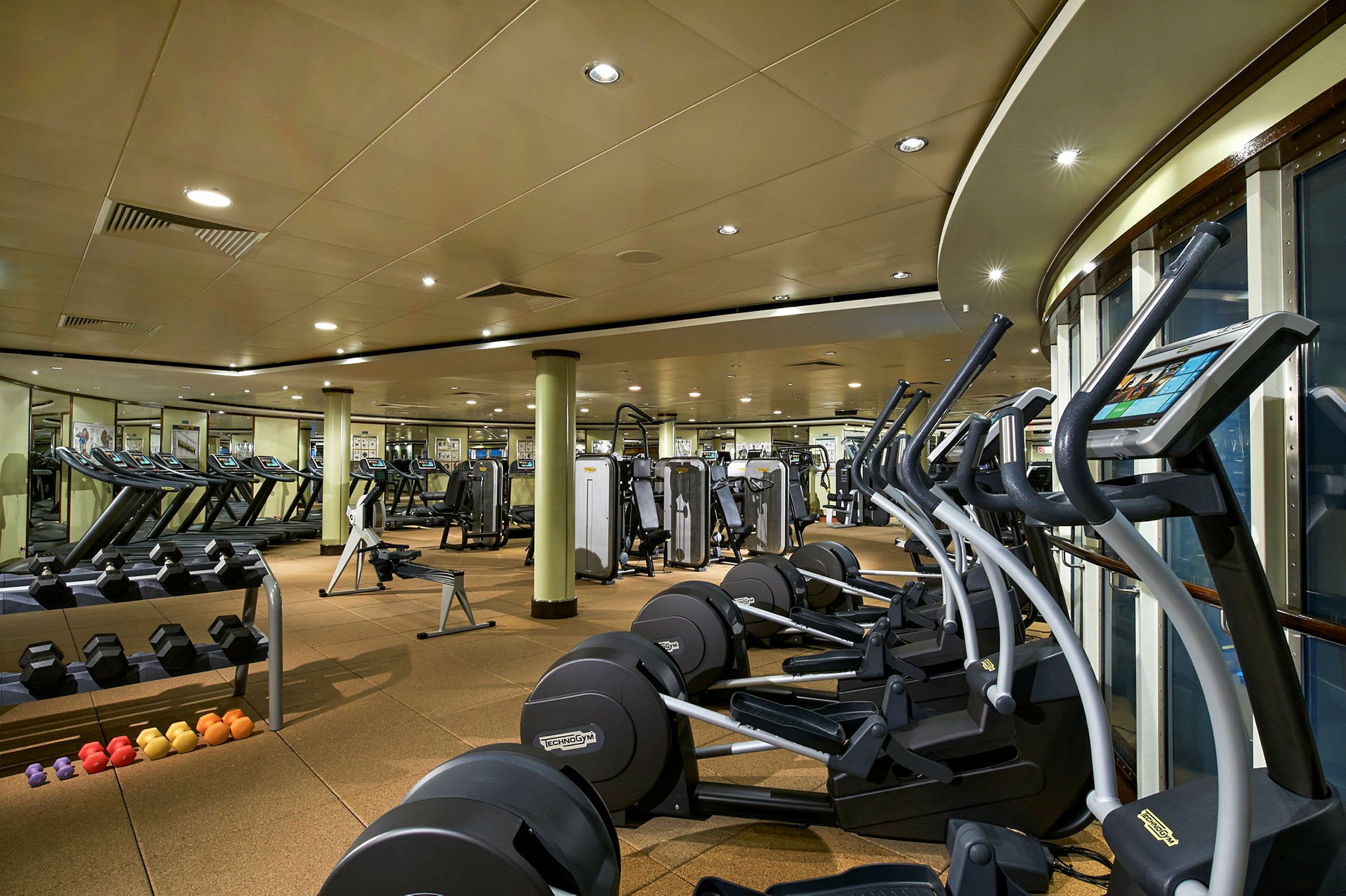 Bild av ett gym med träningsmaskiner, löpband och fria vikter. (AI-genererad text)