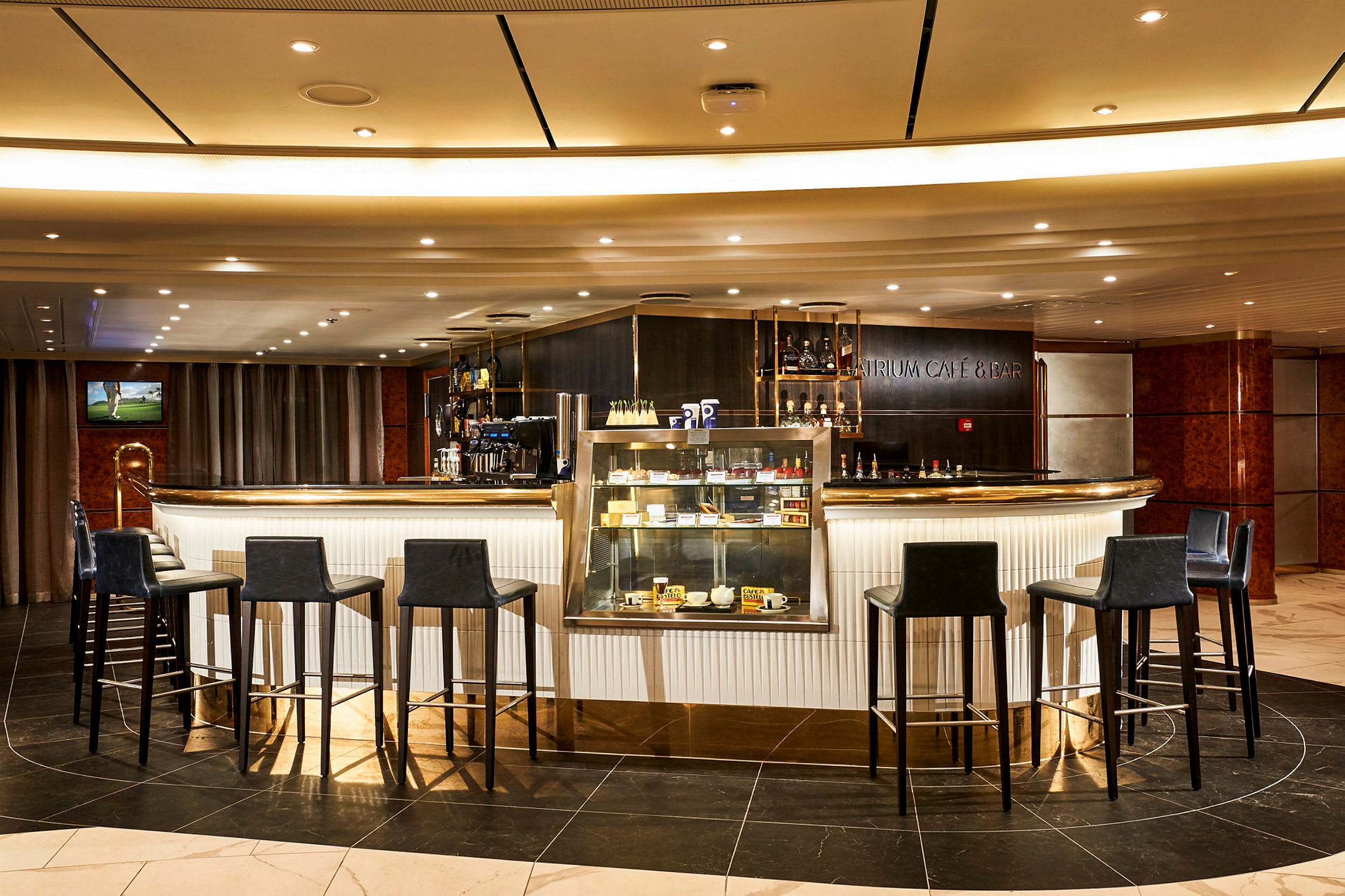 En modern bar med höga stolar och en disk med glasmonter som visar olika produkter. (AI-genererad text)