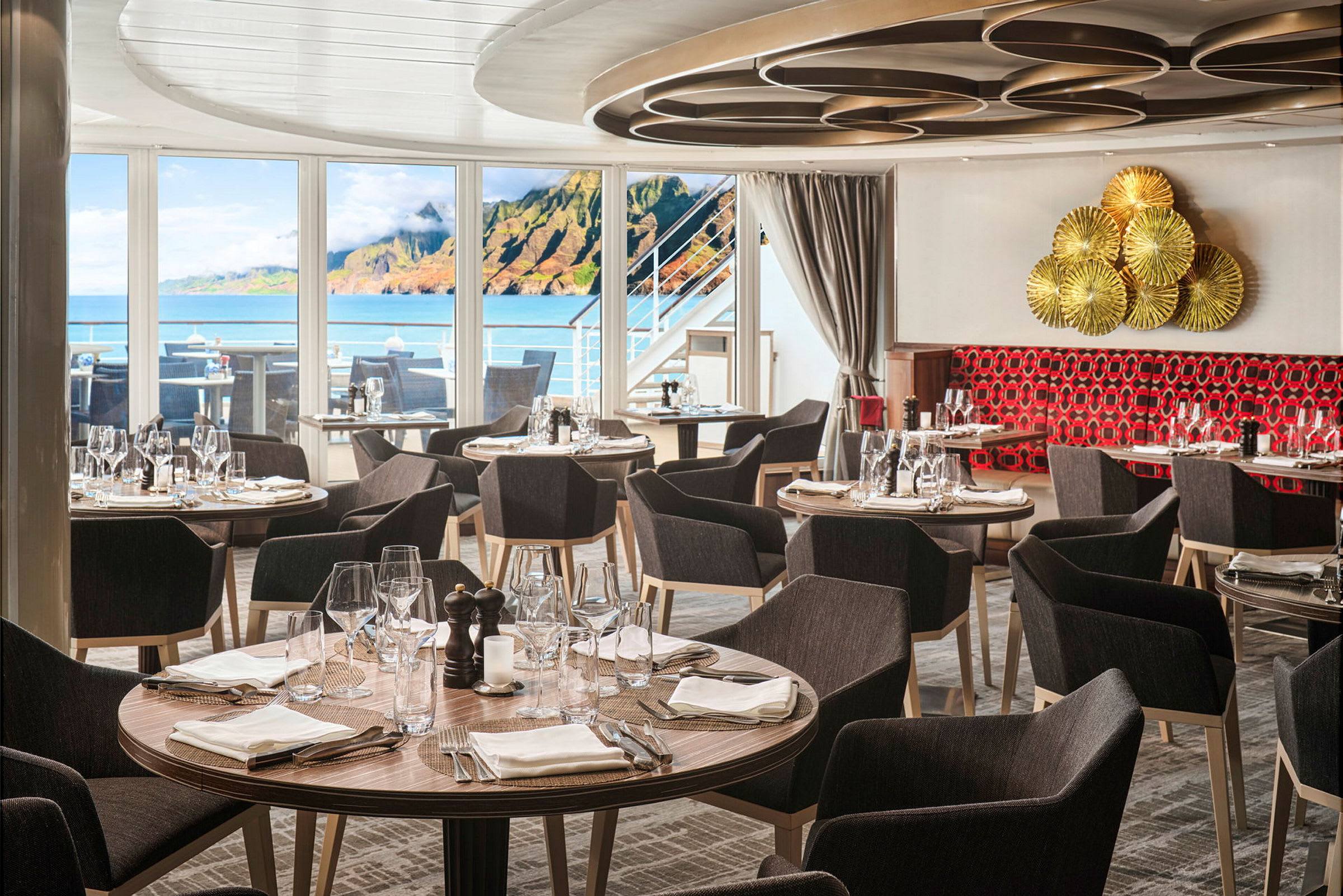 Restaurang med dukade rundabord vid stora fönster som visar en havsutsikt. (AI-genererad text)
