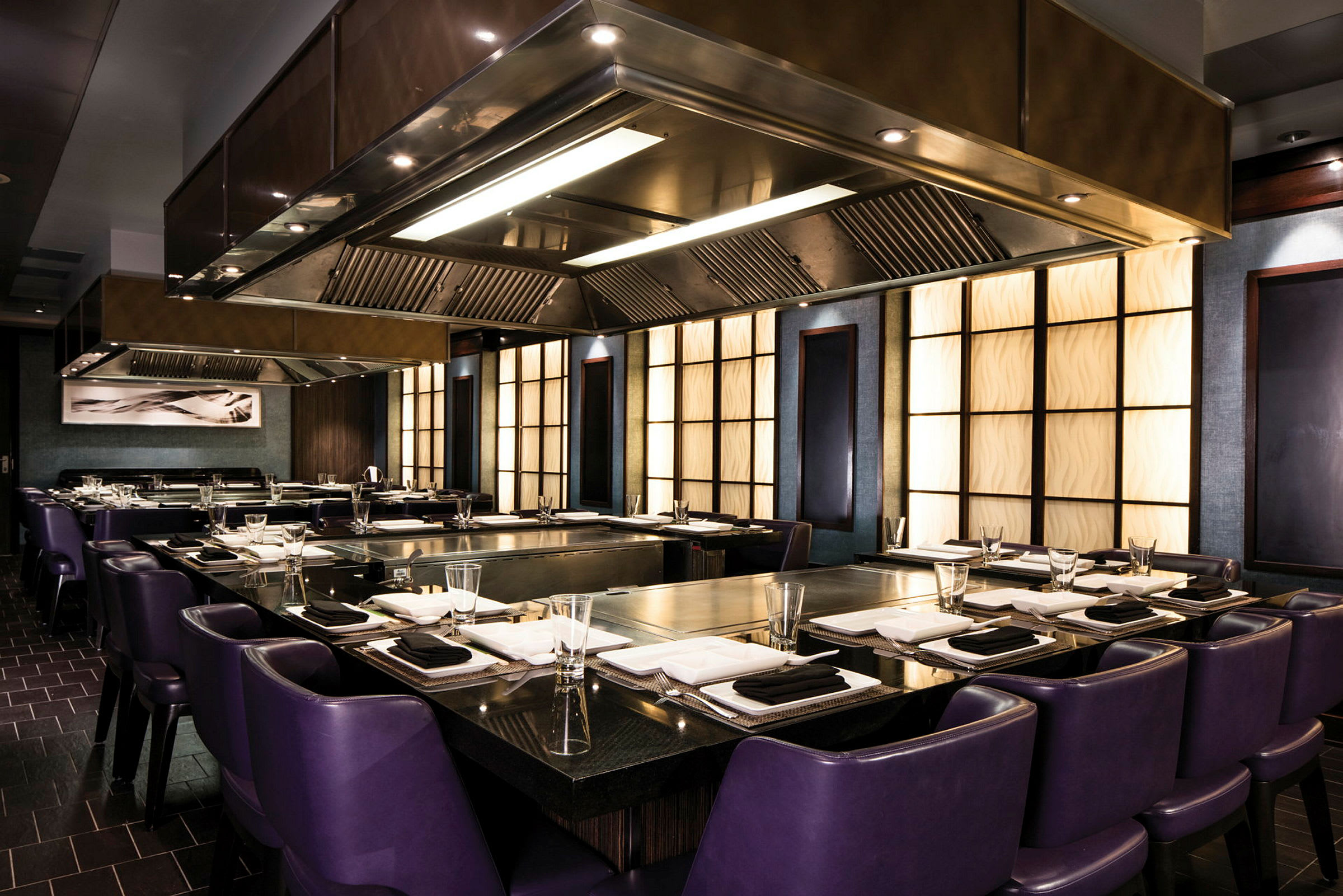 En elegant restaurang med lila stolar och en modern köksinredning. (AI-genererad text)