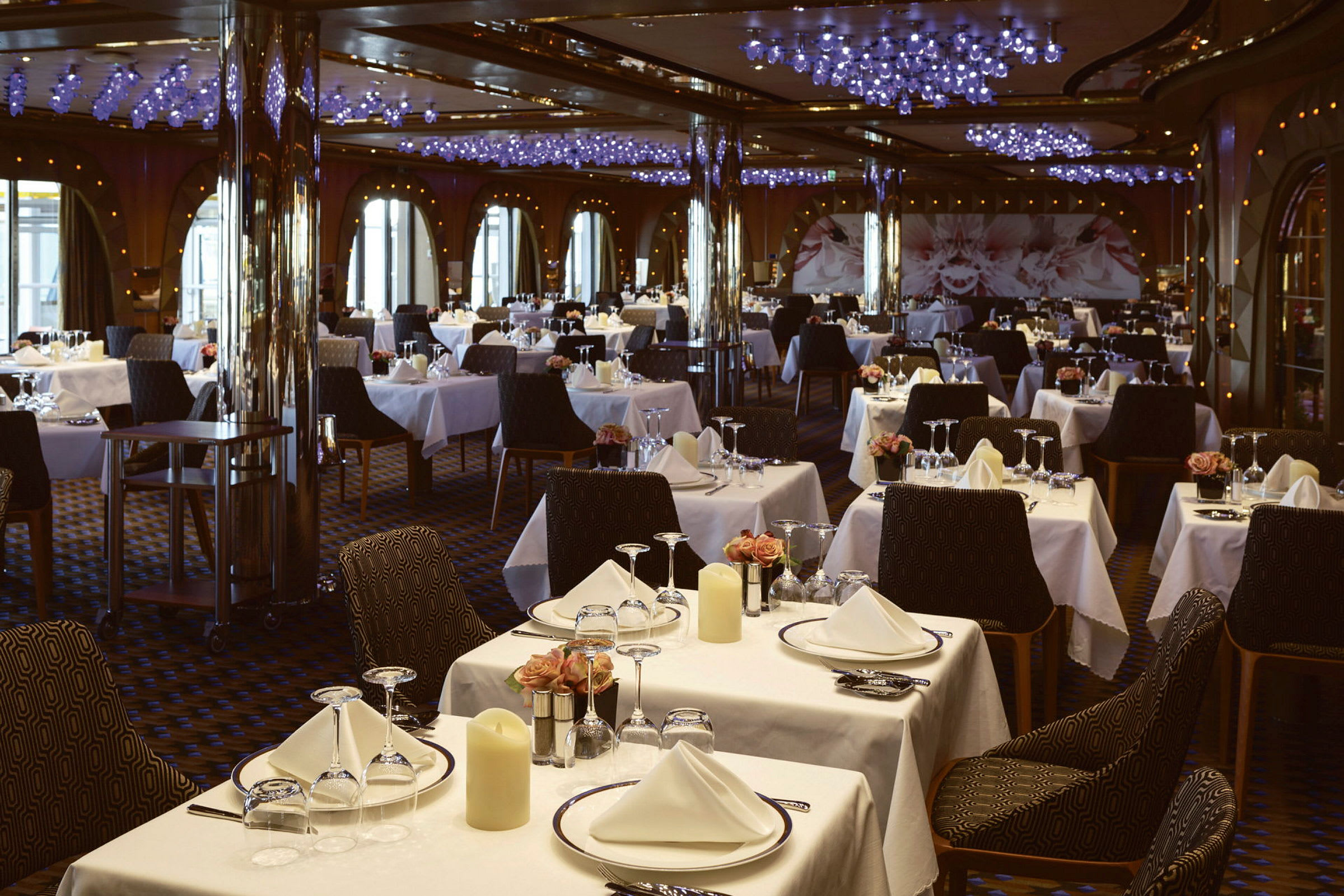 En restaurang med många bord som är dukade med vita dukar, glas och porslin. (AI-genererad text)